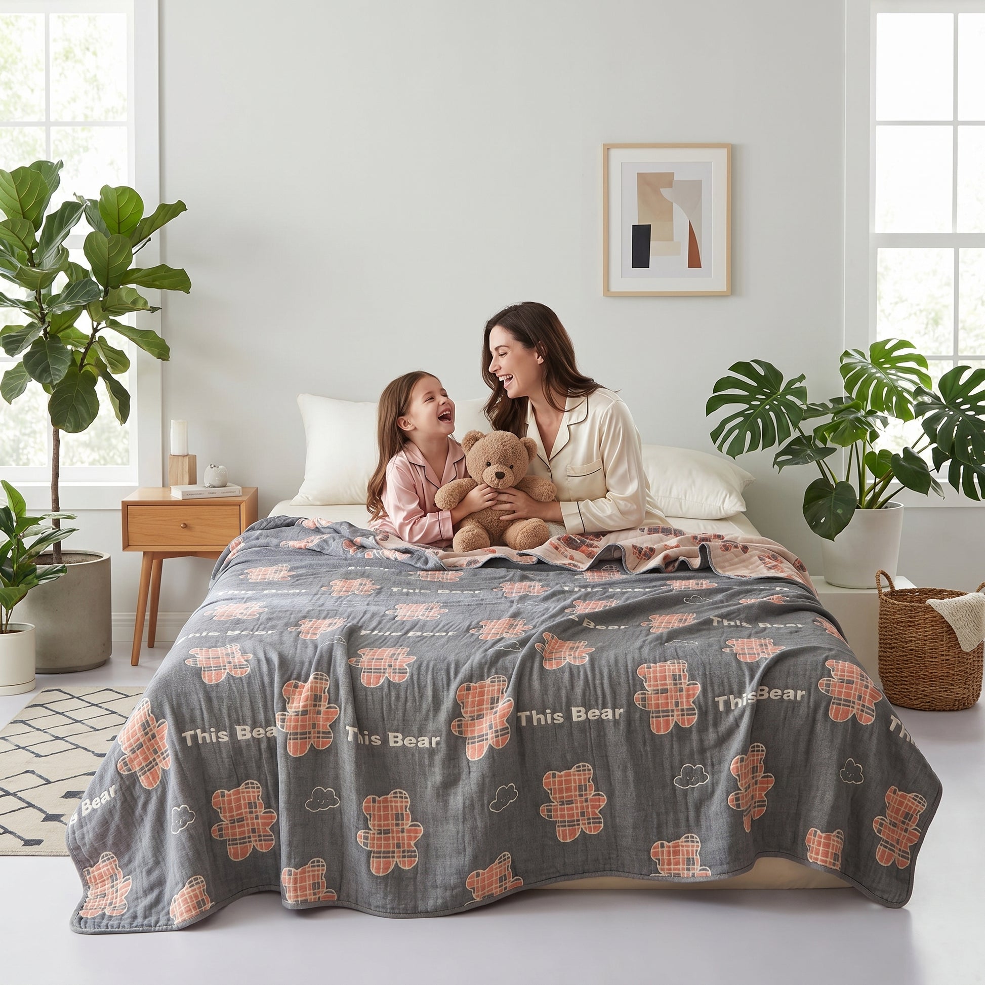 Mother and child on a bed with a gray 6-layer cotton gauze blanket featuring plaid bear and cloud patterns.