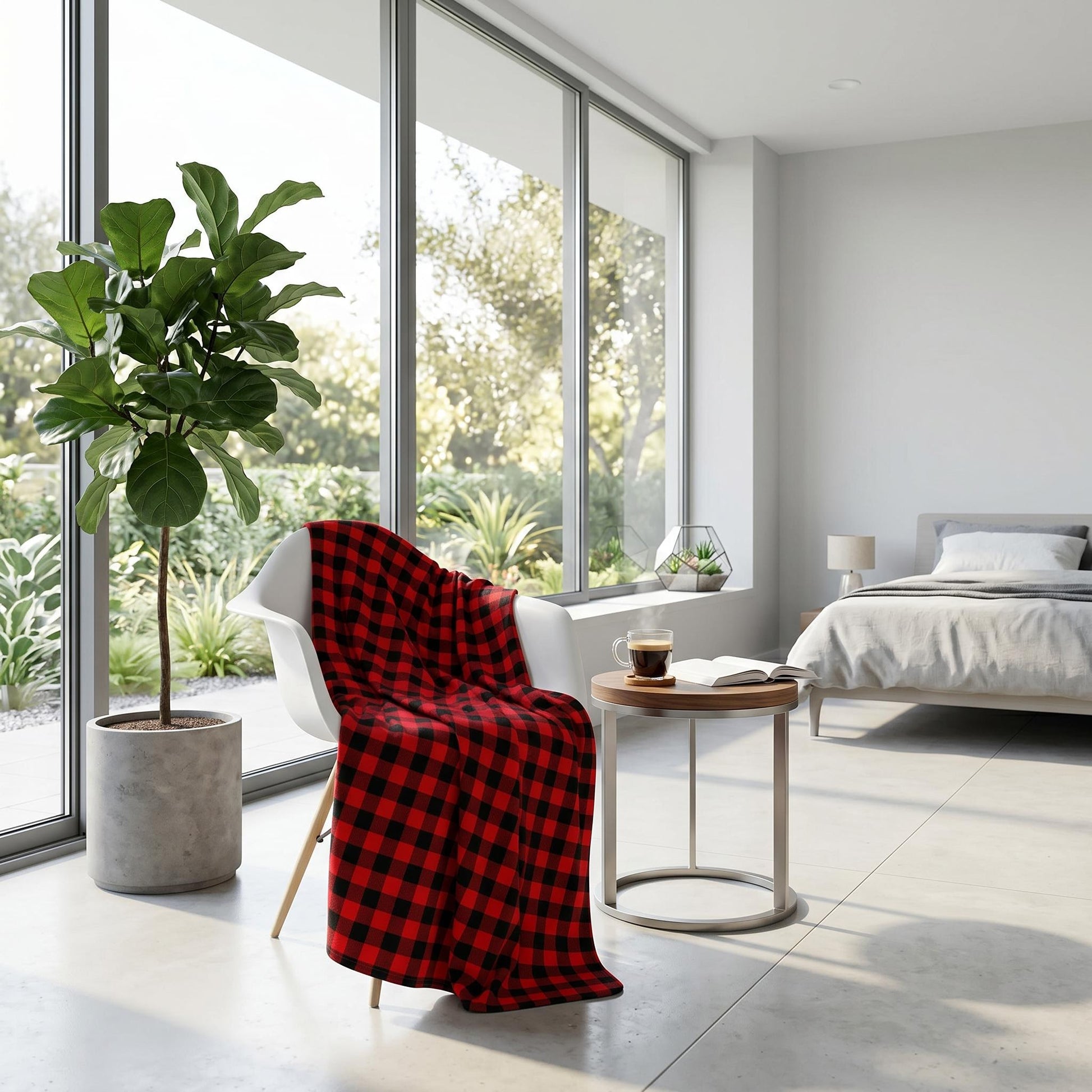Red and black checkered flannel blanket draped over a white chair in a modern bedroom with large windows.