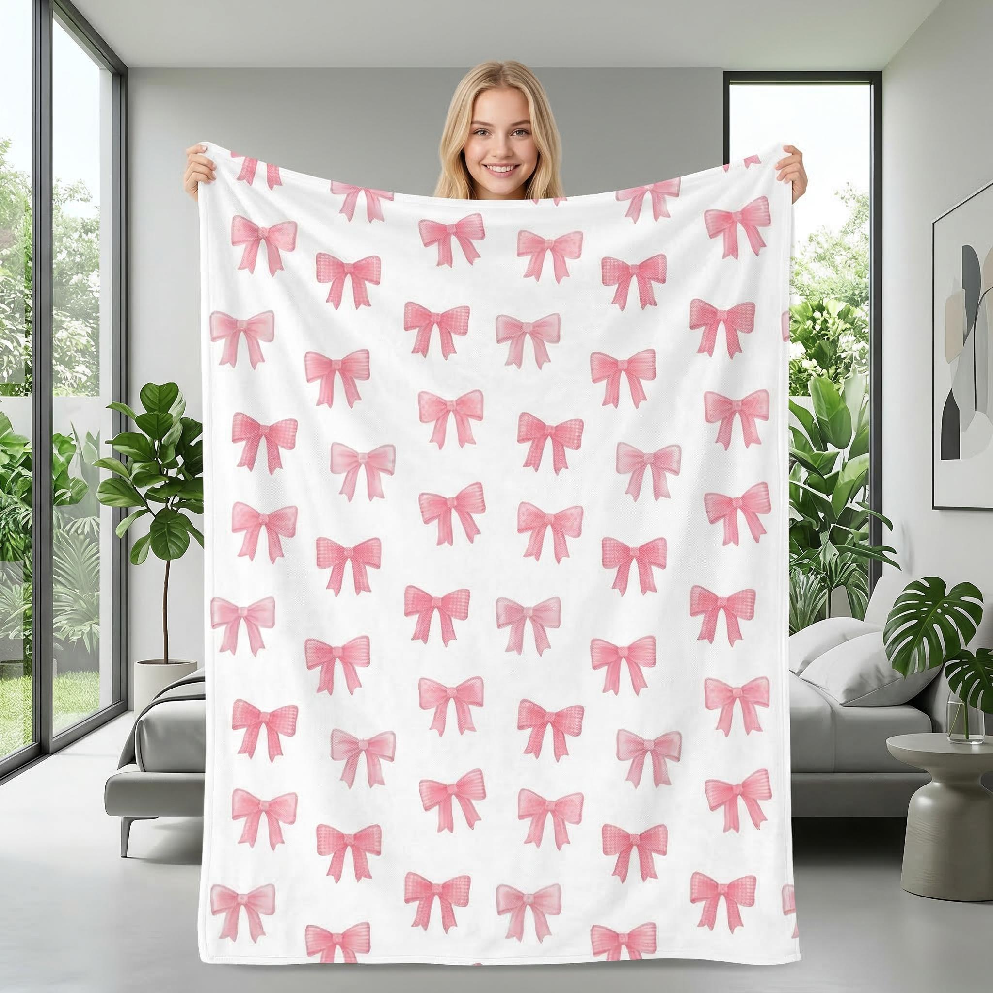 Smiling woman holding a white microfiber flannel blanket with a pink bow pattern.
