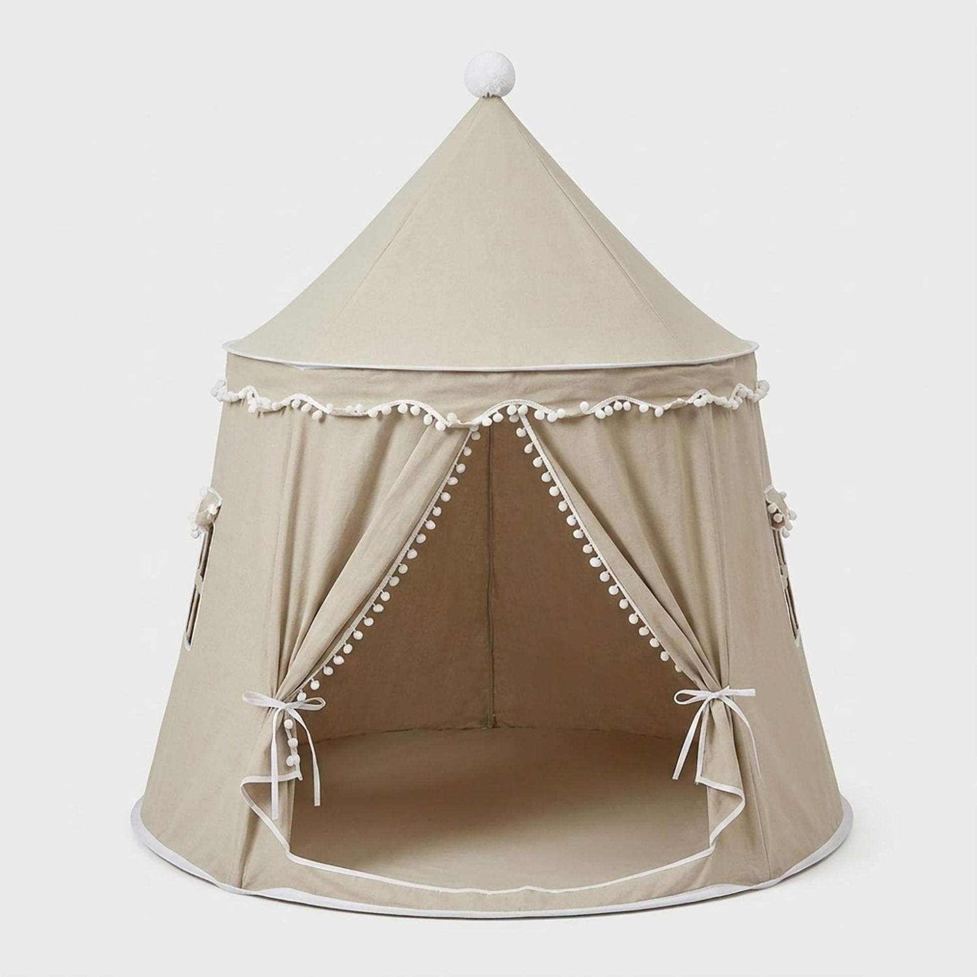 Beige indoor play tent with white trim, pom-poms, and ties, featuring an open entrance and conical roof.