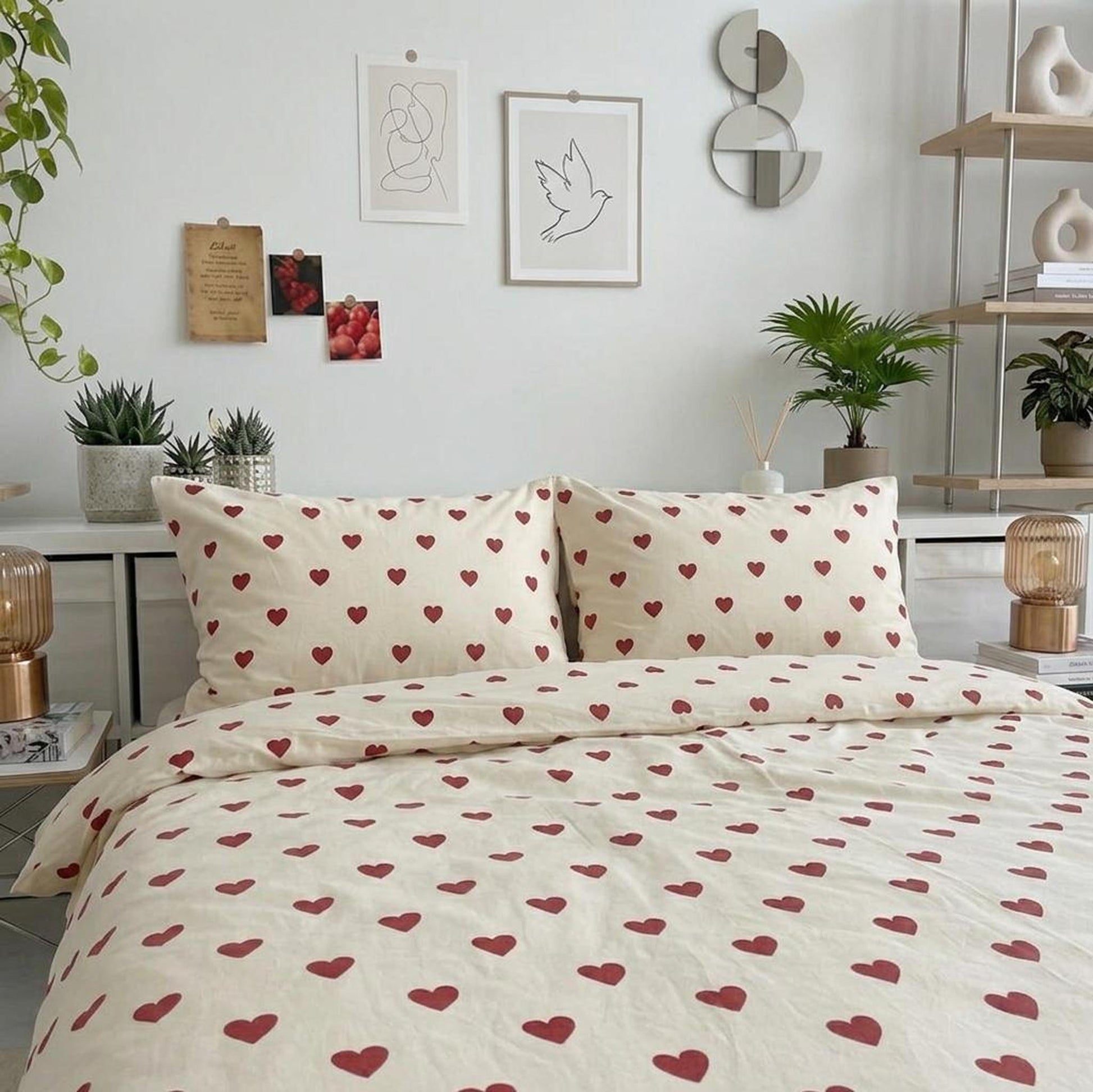 Cream microfiber bedding set with red heart pattern, including duvet cover and two pillowcases, on a bed in a bright room.