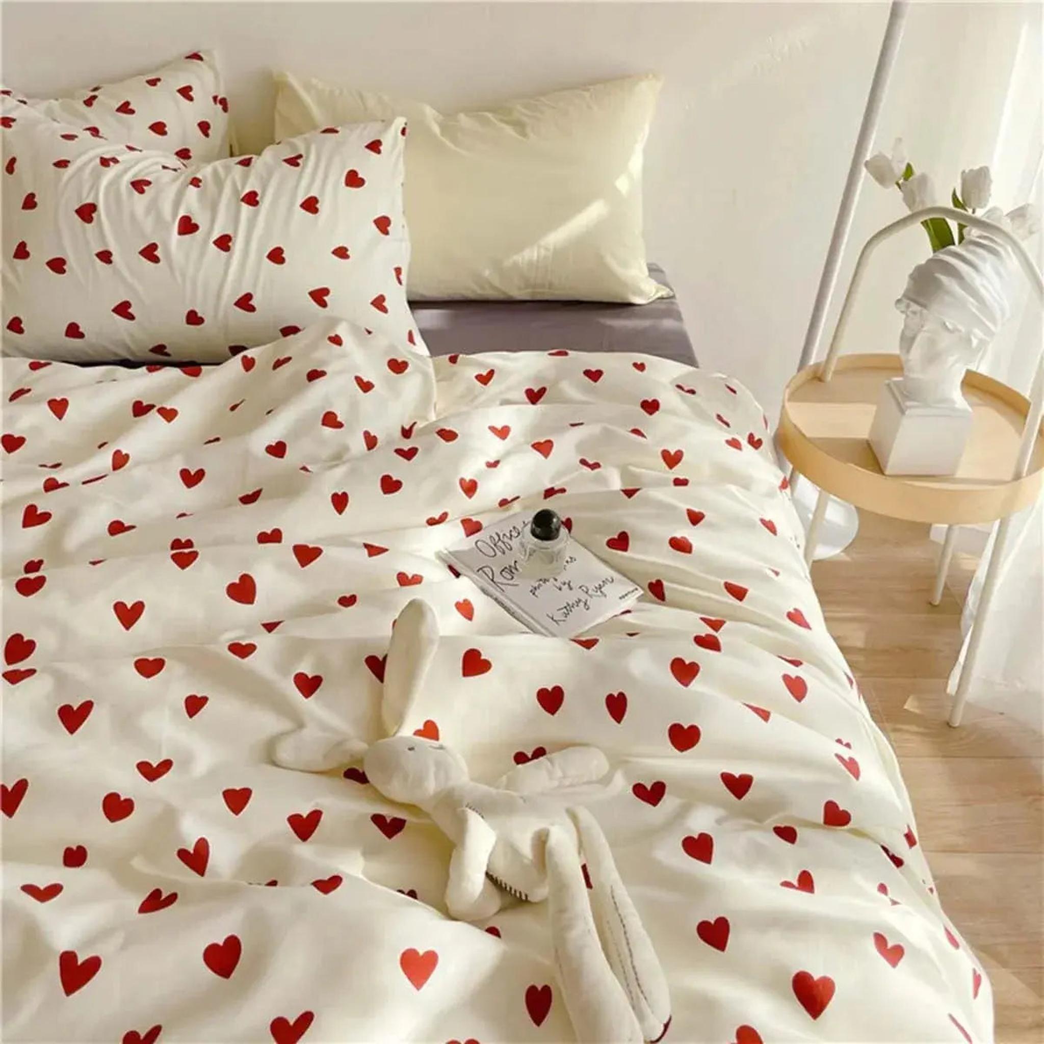 White microfiber bedding set with red heart pattern, including duvet cover and pillowcases.
