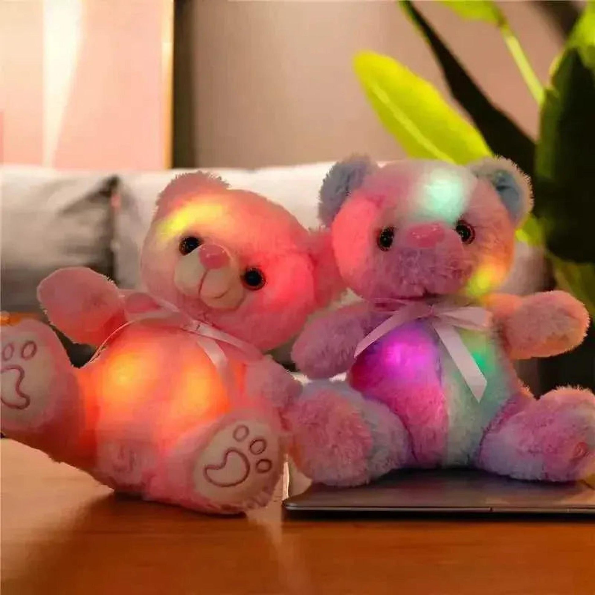 Two glowing plush teddy bears, one pink and one rainbow-colored, with soft LED lights.