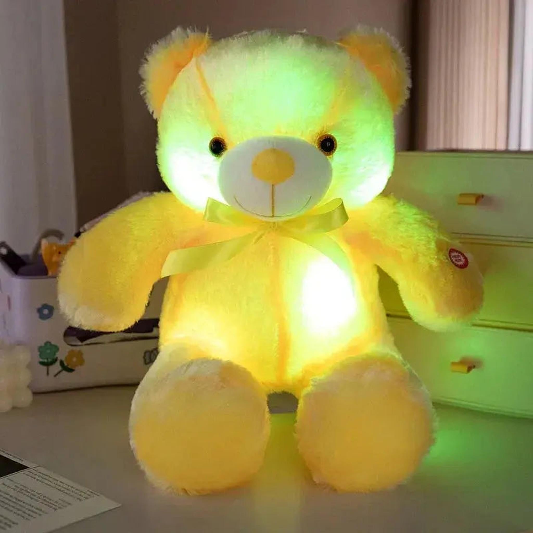 Yellow plush teddy bear glowing with a soft green LED light, featuring a yellow ribbon.