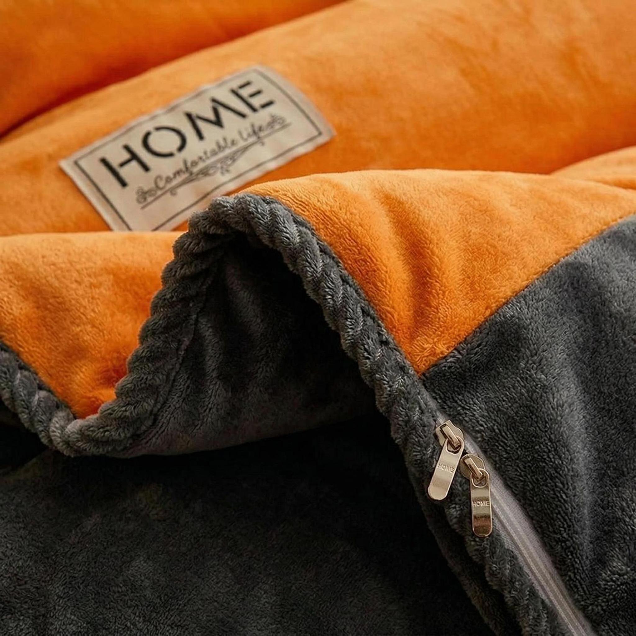 Thick orange and grey lamb wool fleece blanket with a zipper and a "HOME" label.