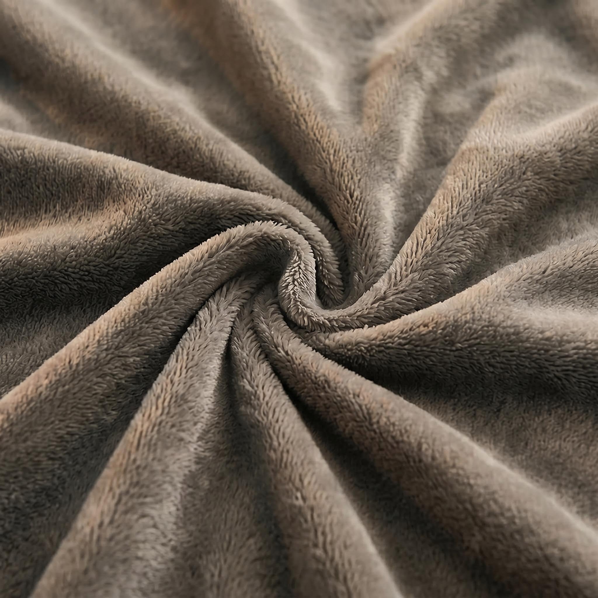 Close-up of a soft, brown lamb wool fleece blanket swirled into a plush spiral texture.