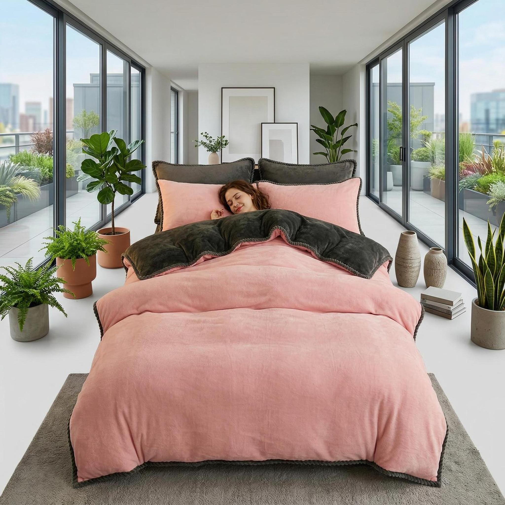 Thick pink and grey lamb wool fleece blanket on a bed in a modern room.