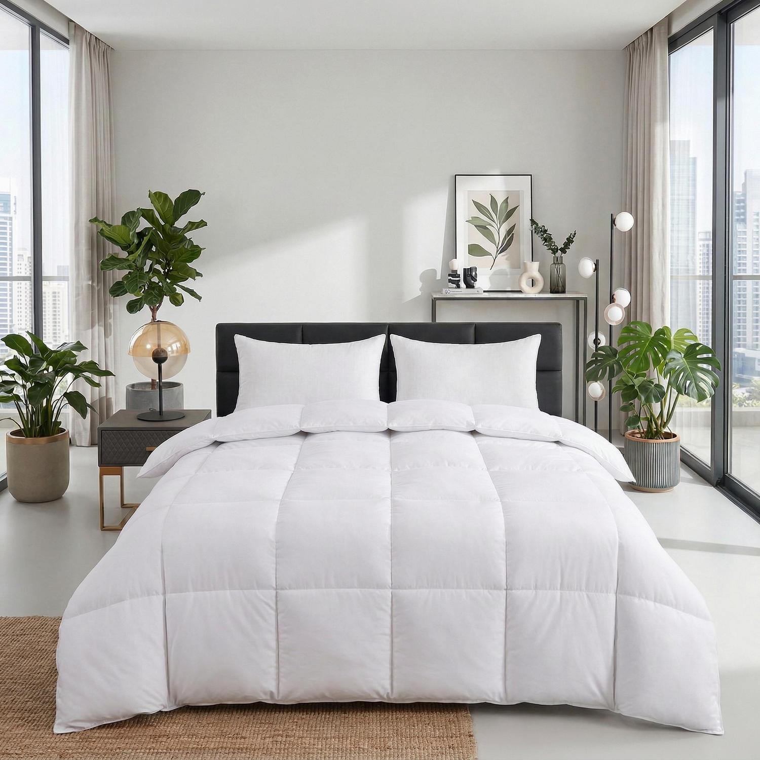 White fluffy quilted comforter and two pillows on a bed in a modern bedroom.