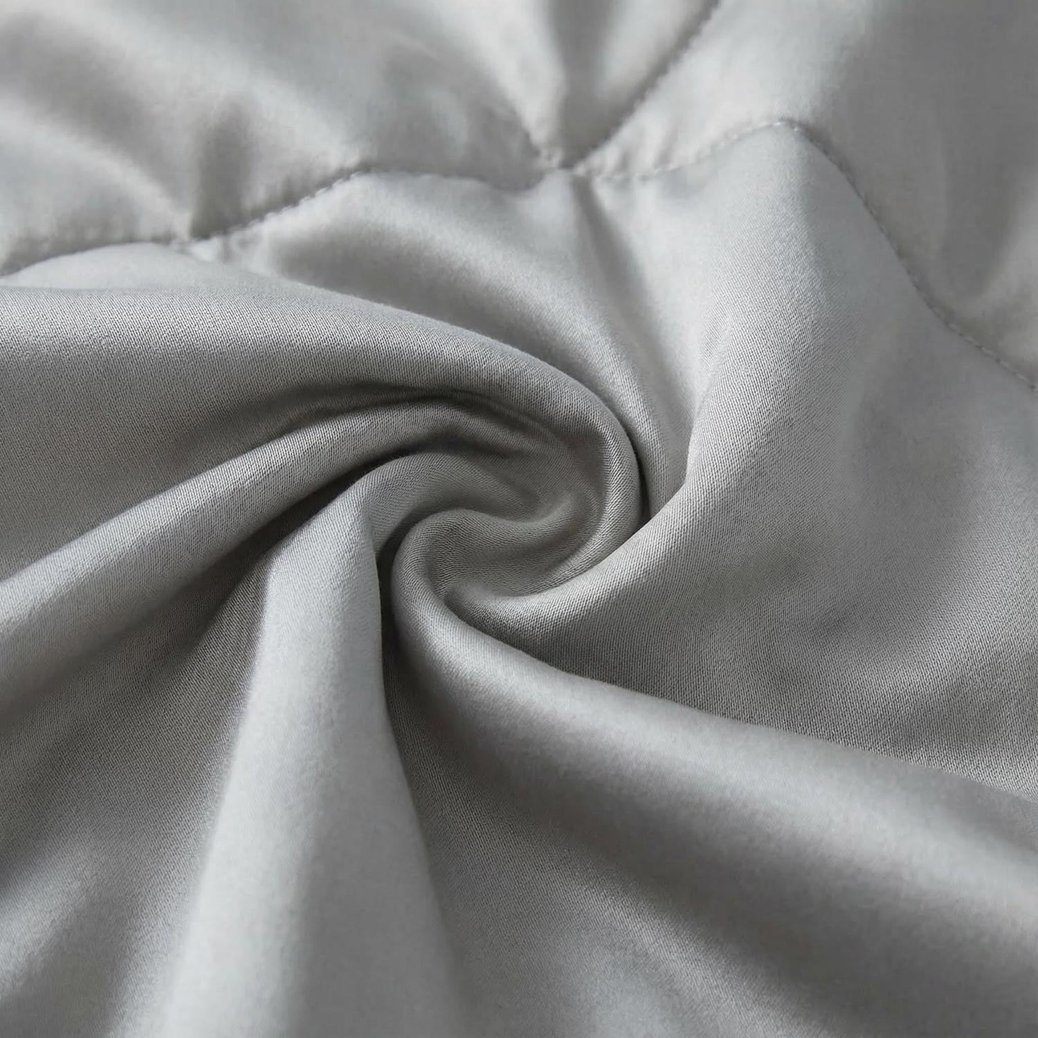 Close-up of a soft, light gray wave-quilted summer AC quilt, showing its skin-friendly fabric.