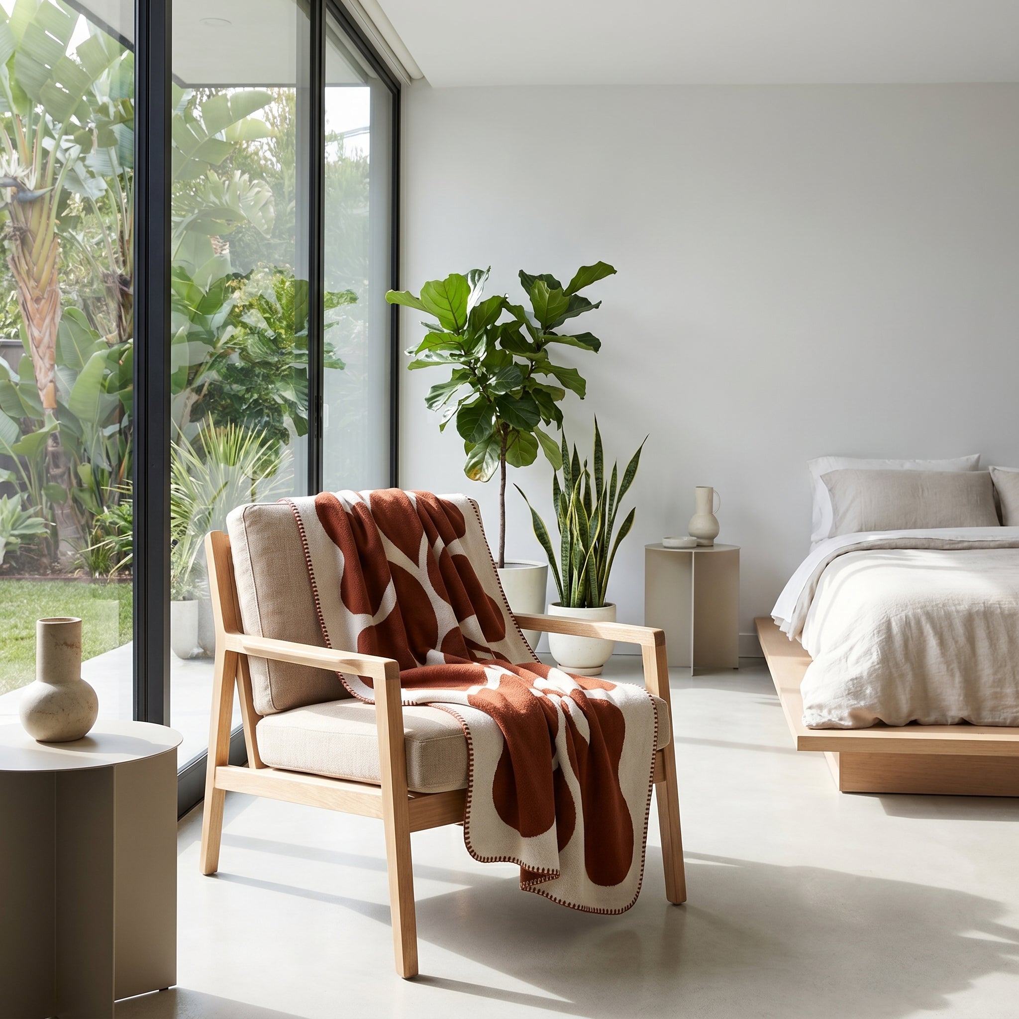 LunaGrid Monochrome Throw Blanket draped over a light wood armchair in a modern bedroom.