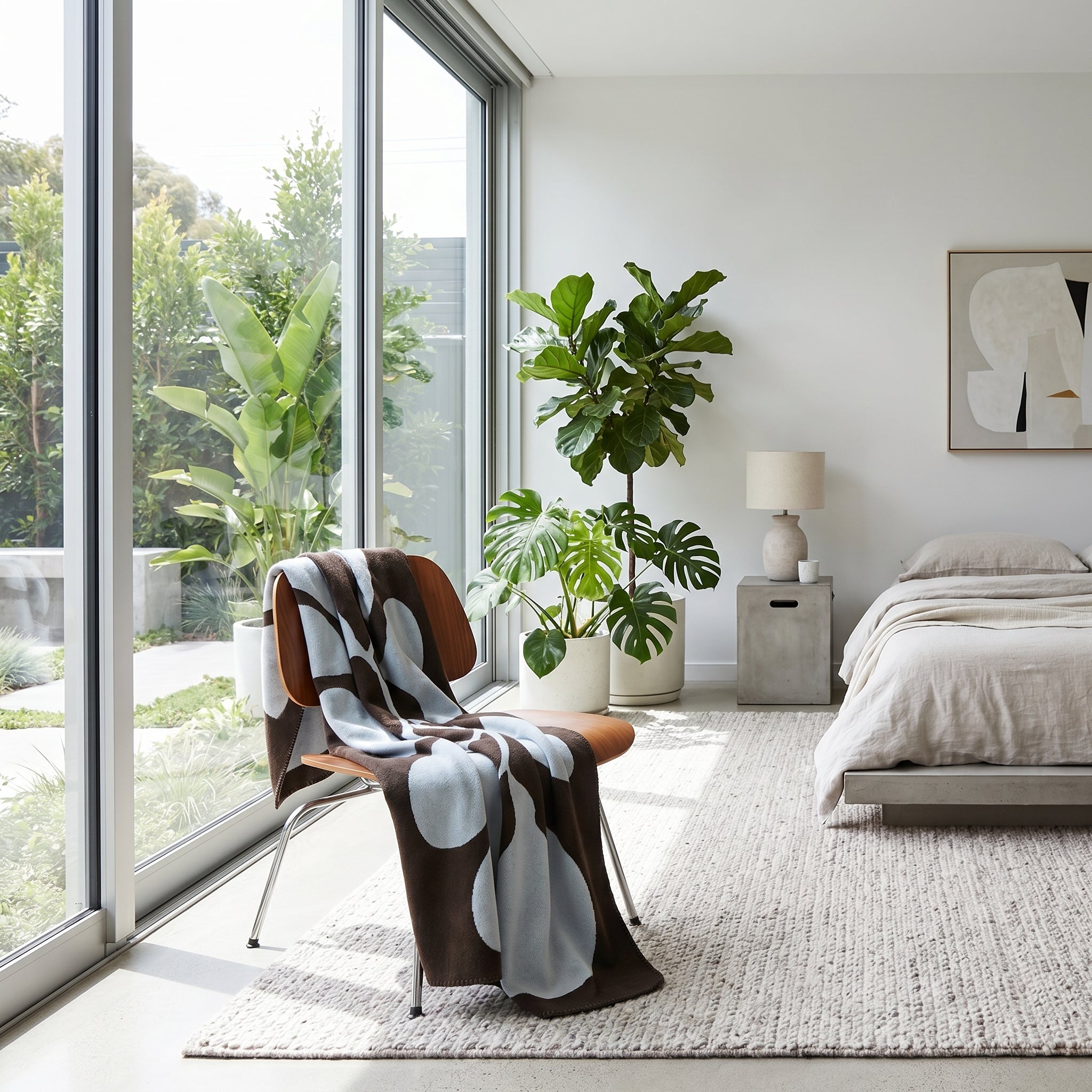 Brown and light blue LunaGrid monochrome throw blanket draped over a modern wooden chair in a bright room.