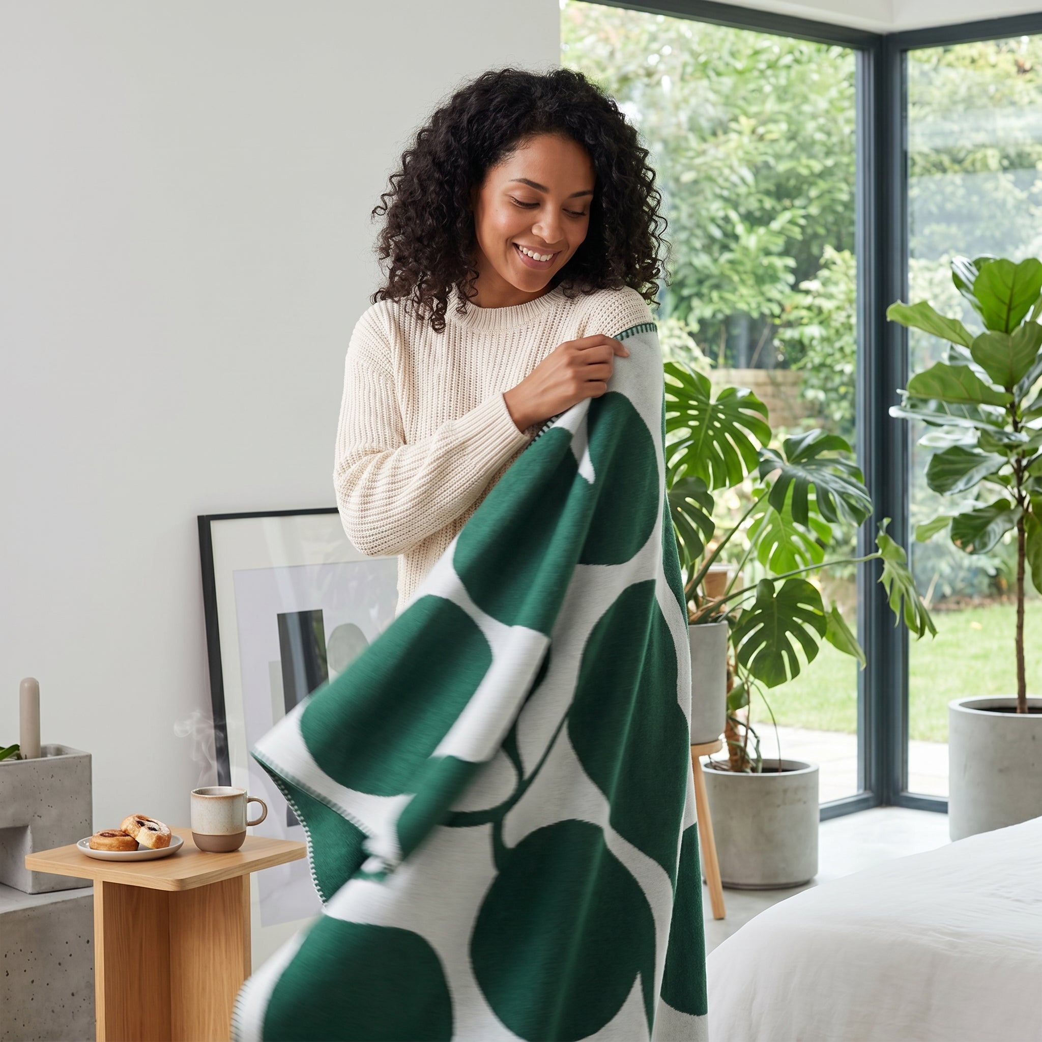 Smiling woman holding a green and white LunaGrid throw blanket with a bold circular pattern.