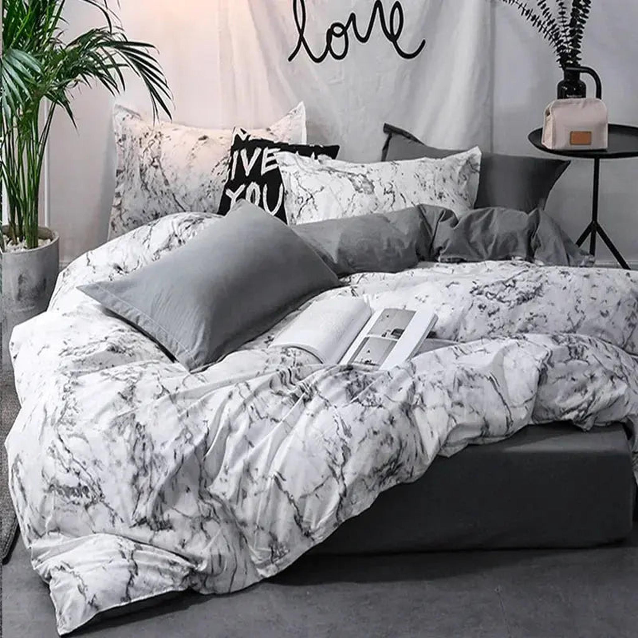 Dark marble print microfiber duvet cover set with grey pillows on a modern bed.
