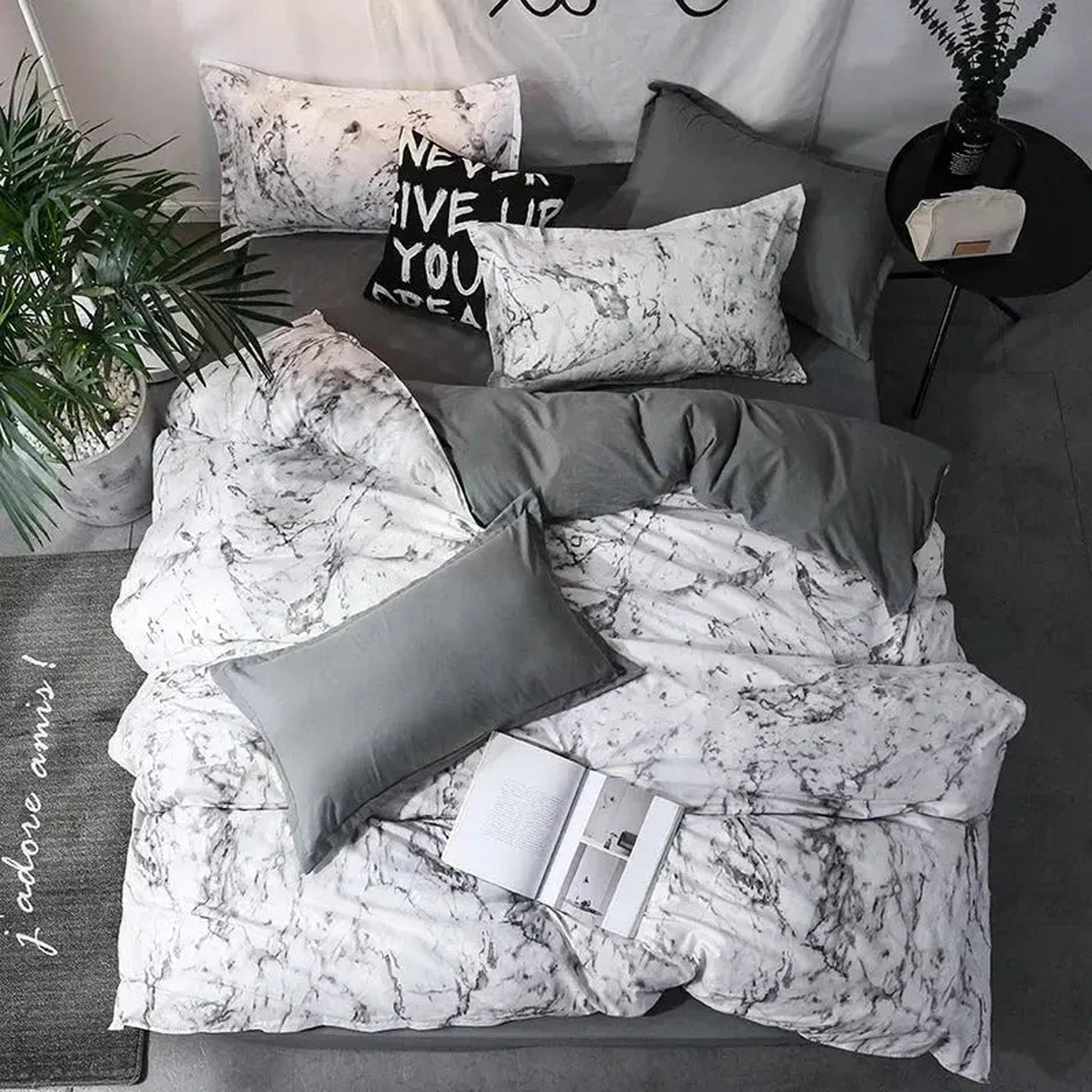White and gray marble print duvet cover set with solid gray accents on a bed.