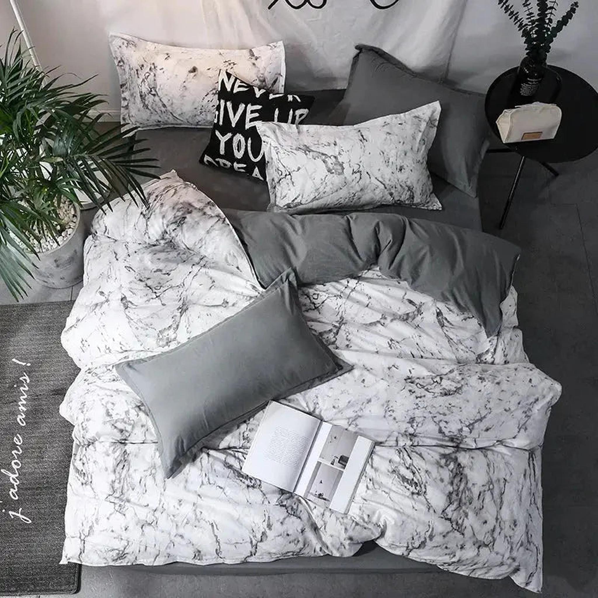 White and gray marble print duvet cover set with solid gray accents on a bed.