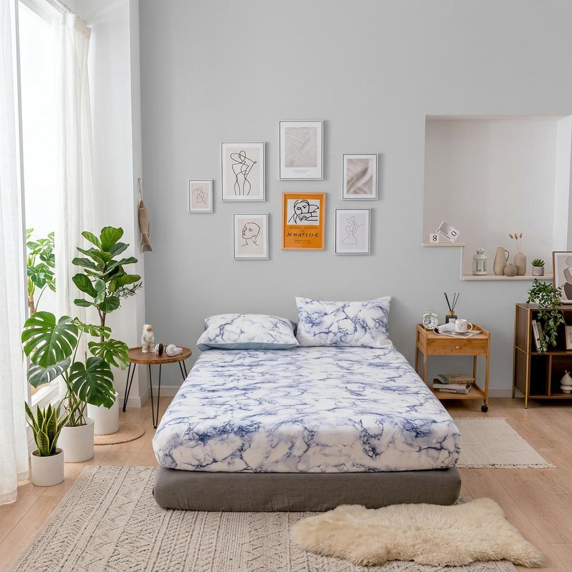 White and blue marble print microfiber fitted sheet with matching pillowcases on a bed in a modern bedroom.