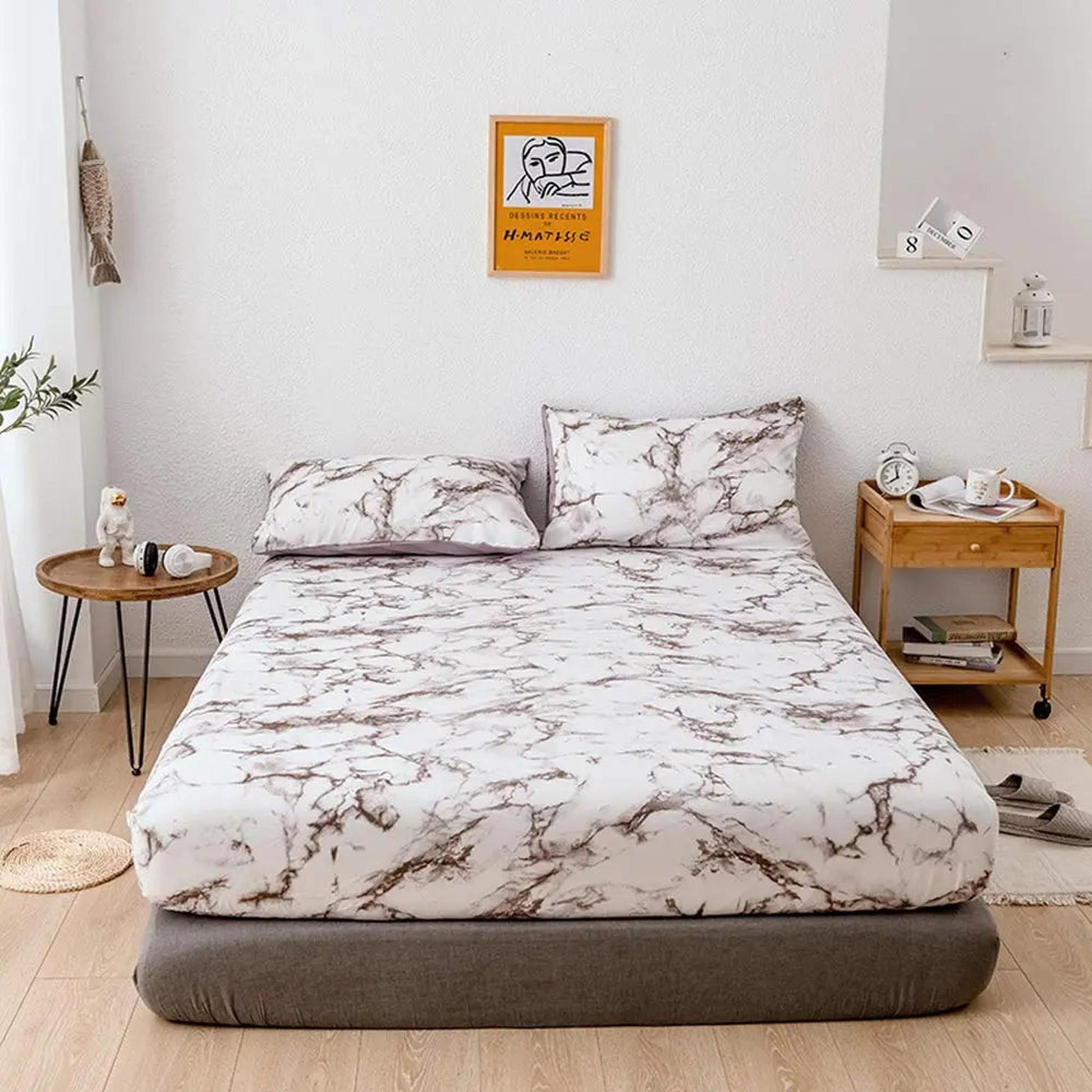 White microfiber fitted sheet with brown marble print, two matching pillowcases, on a bed in a modern bedroom.