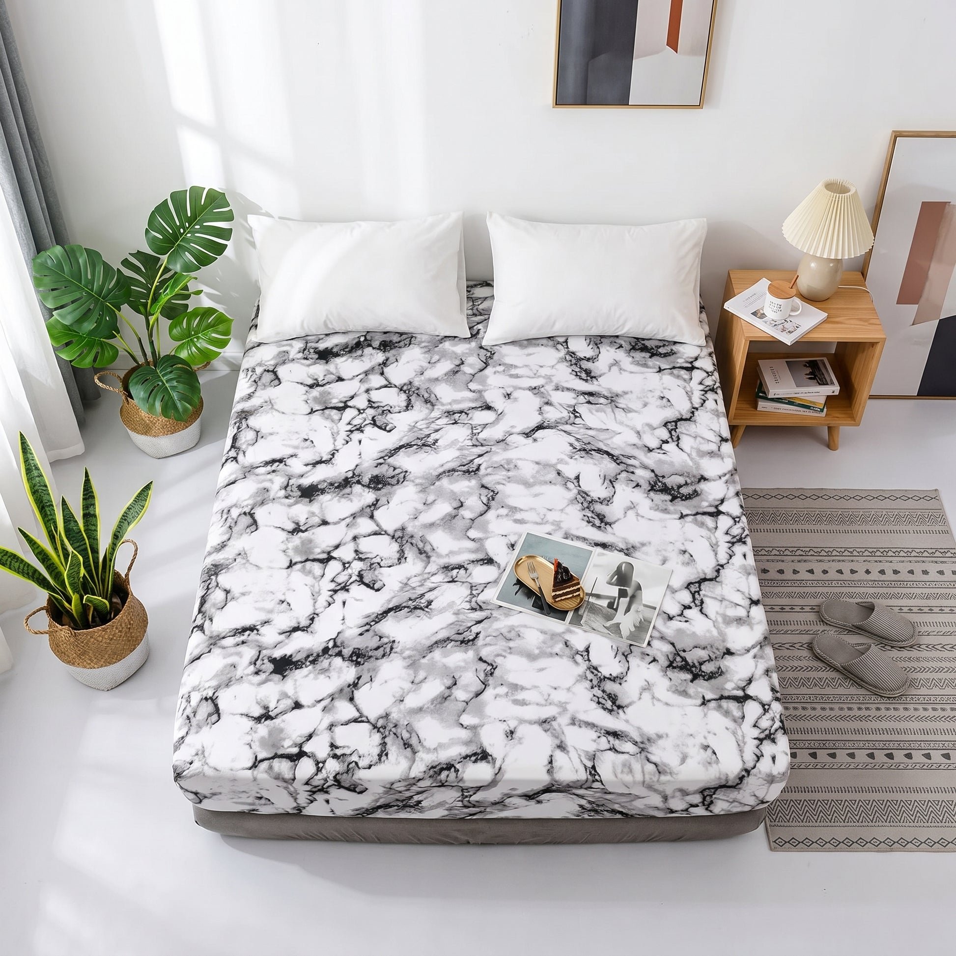 White and black marble print microfiber fitted sheet on a bed with white pillows, plants, and a wooden nightstand.