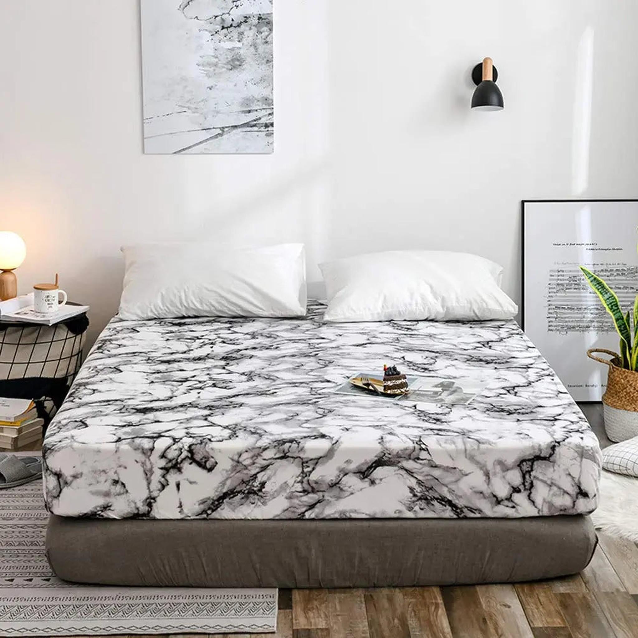White and black marble print microfiber fitted sheet on a bed with white pillows.