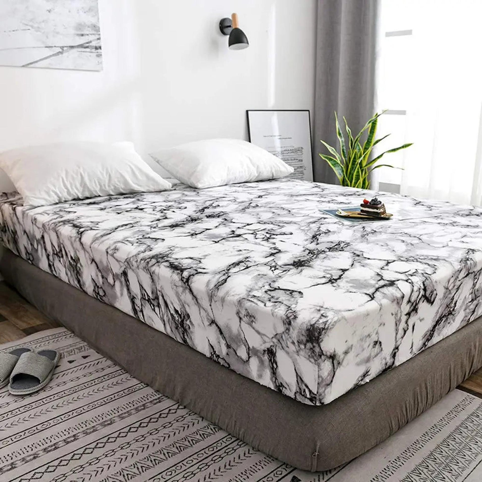 White and black marble print microfiber fitted sheet on a bed with white pillows.