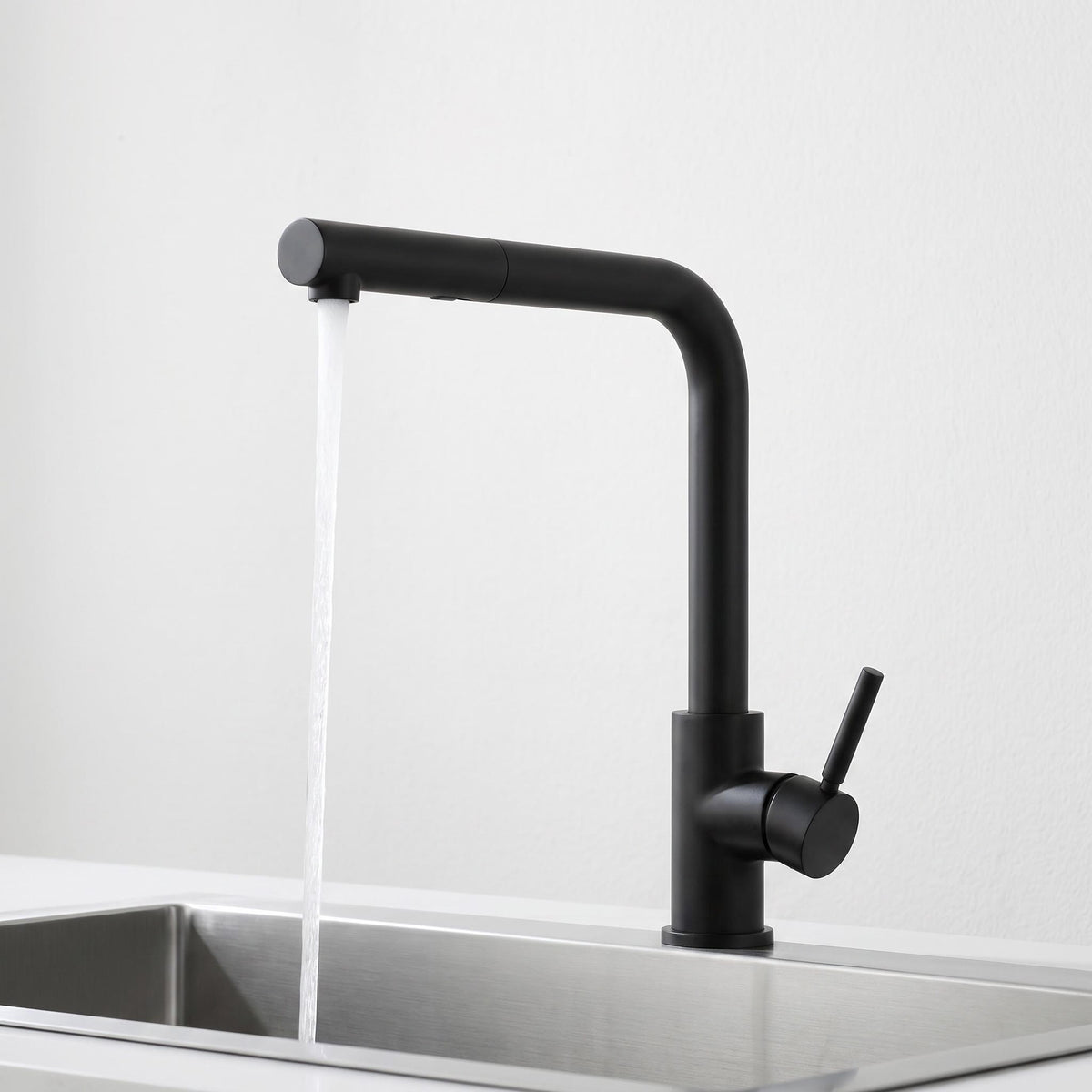Modern matte black stainless steel pull-out kitchen faucet with a single handle and water flowing into a sink.