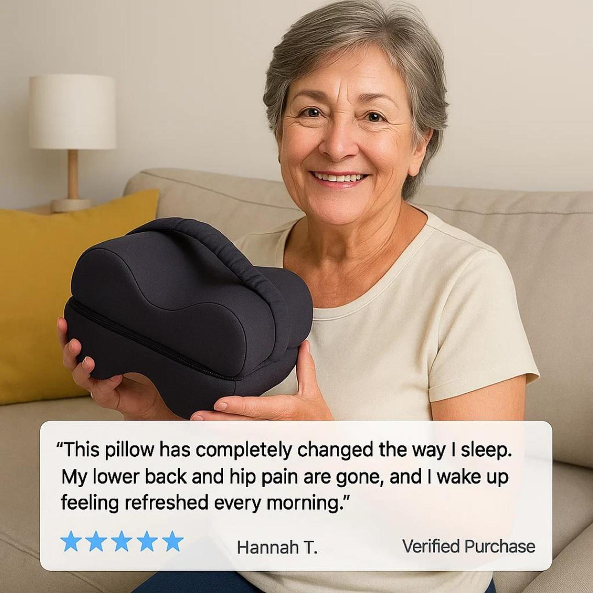 Smiling woman holding a dark gray ergonomic memory foam knee pillow with a removable cover.