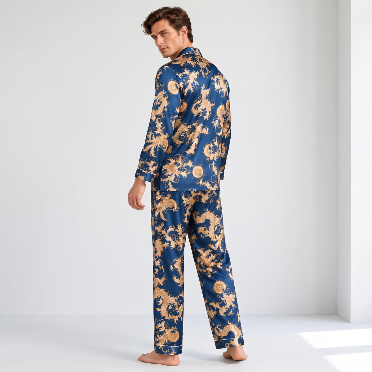 Man wearing a blue mulberry silk pajama set with a gold dragon print, featuring a classic notch collar and relaxed fit.