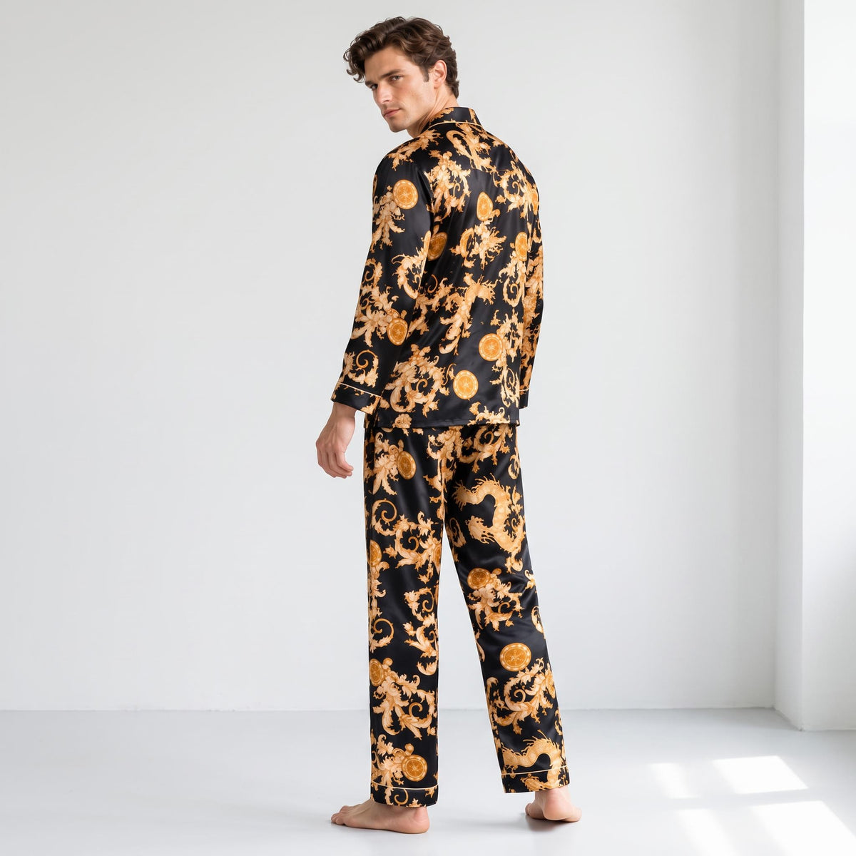 Man wearing a black and gold dragon print mulberry silk pajama set with a notch collar and long sleeves.