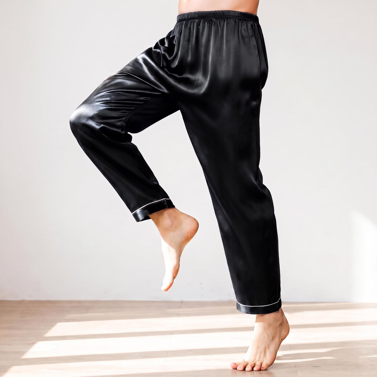 Black men's pajama pants made of 100% mulberry silk with an elastic waistband and white trim detail.