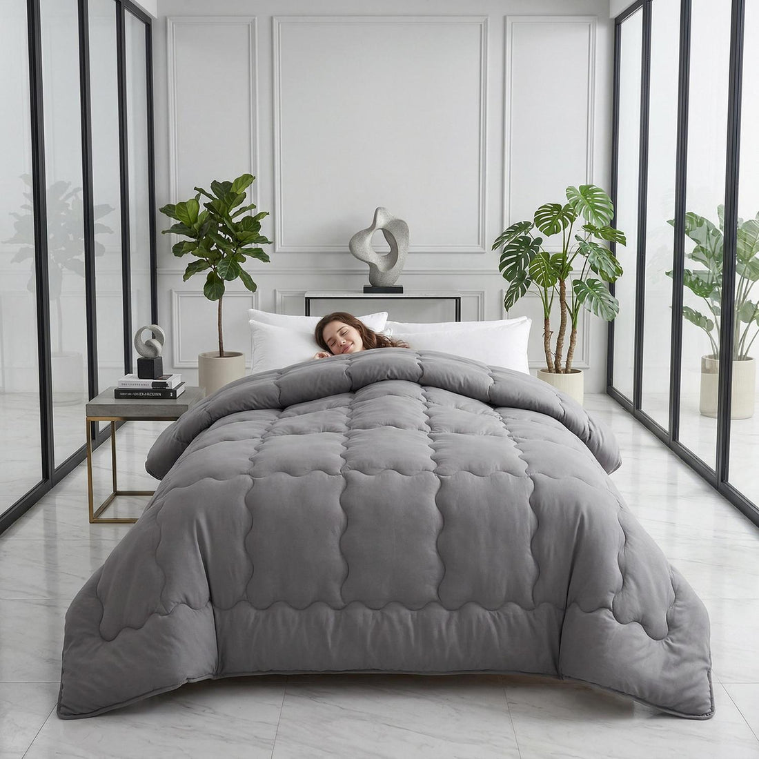 Woman sleeping peacefully under a gray minimalist solid color quilt comforter in a modern bedroom.