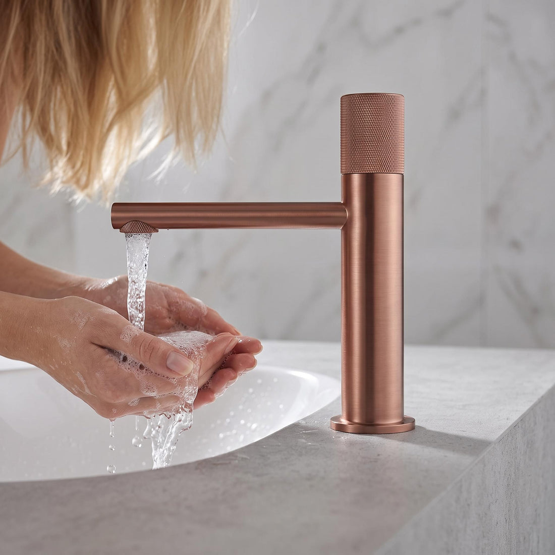 Modern copper-finish brass bathroom faucet with a textured diamond-patterned single handle and matching drain cover.