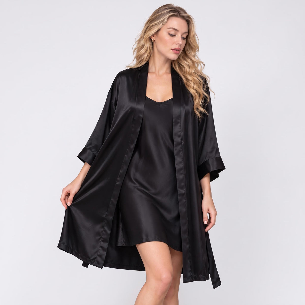 Woman wearing a luxurious black mulberry silk kimono robe and matching spaghetti strap nightgown set.