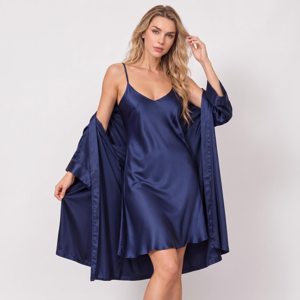 Woman wearing a navy blue mulberry silk kimono robe and matching spaghetti strap nightgown set.