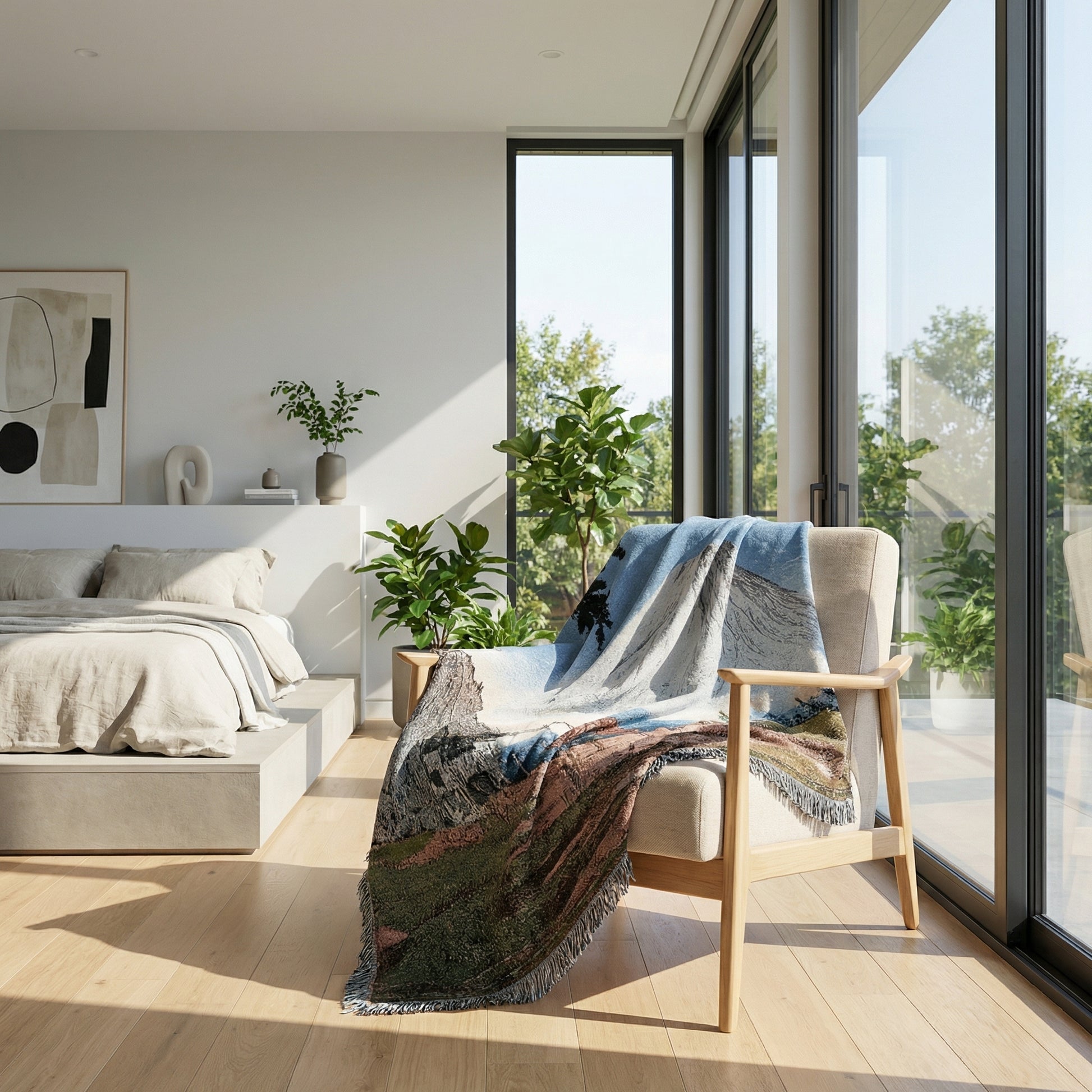 Natural landscape knitted throw blanket draped over a light beige armchair in a bright room.