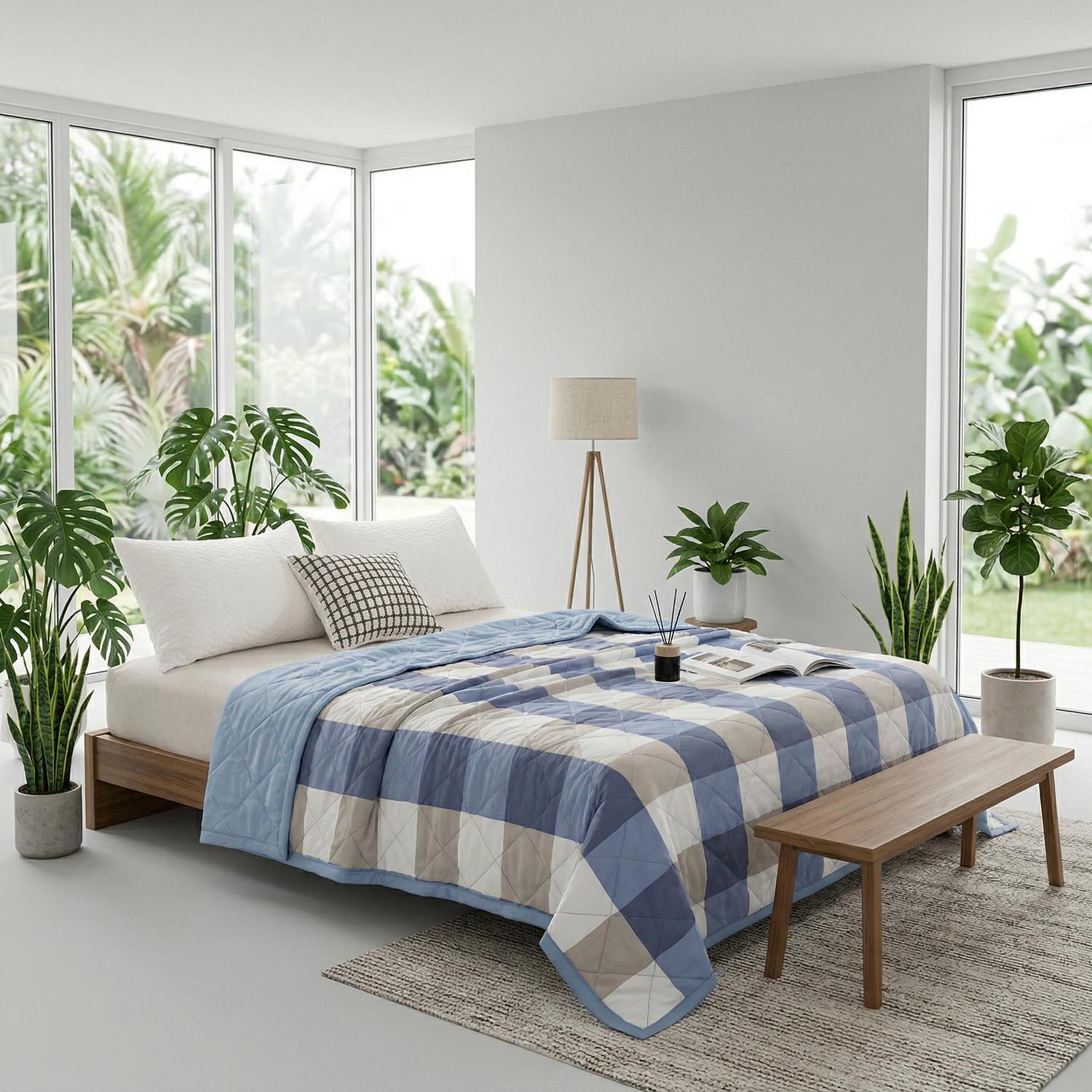 Blue and beige plaid lightweight summer quilt on a bed in a bright, modern bedroom.