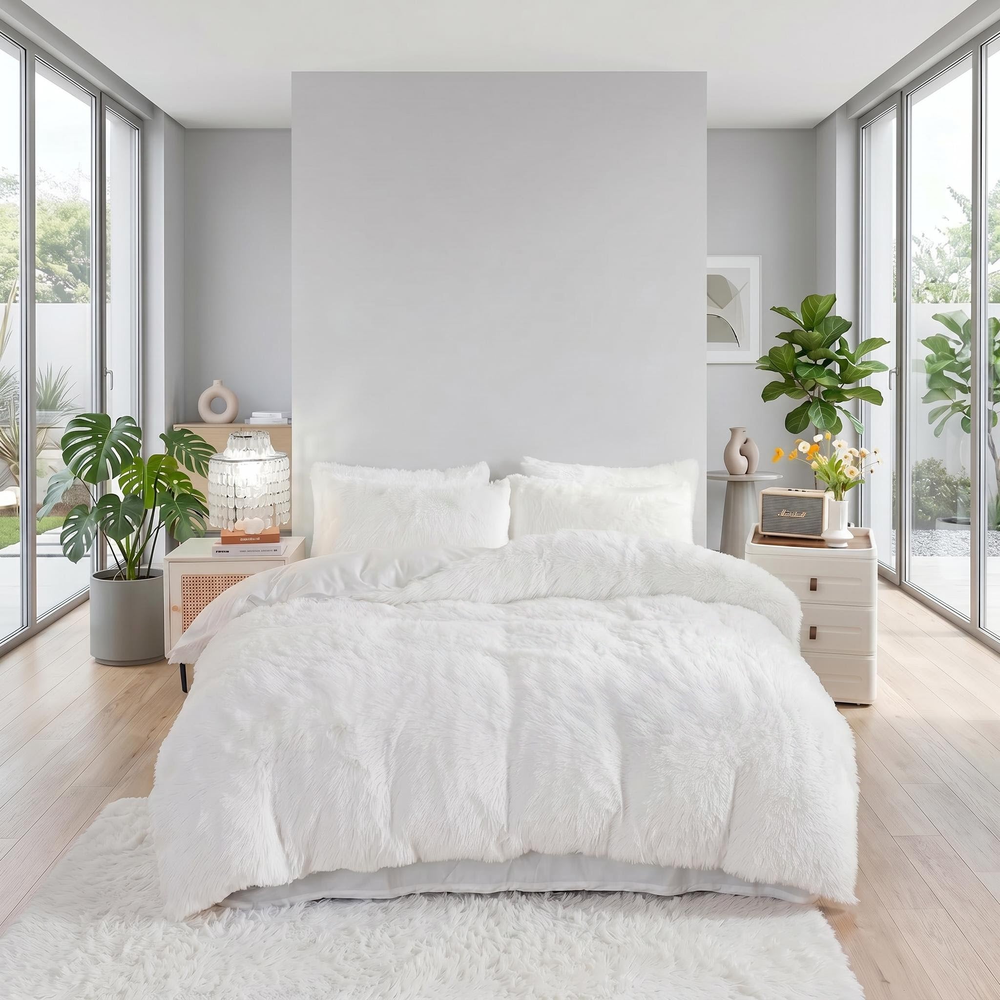 White plush faux fur duvet cover set with two pillows on a bed in a modern bedroom.