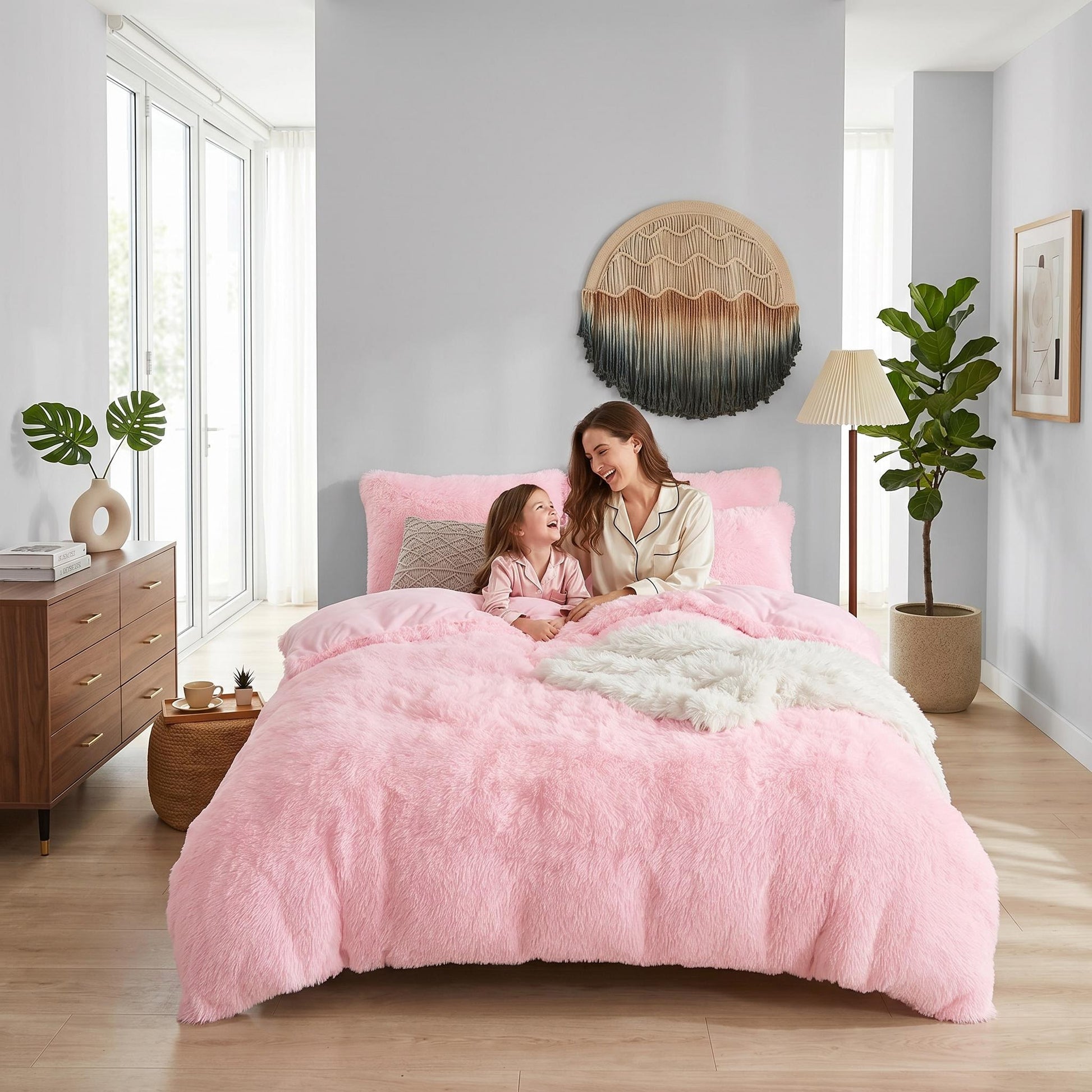 Pink plush faux fur duvet cover set on a bed with a mother and child.