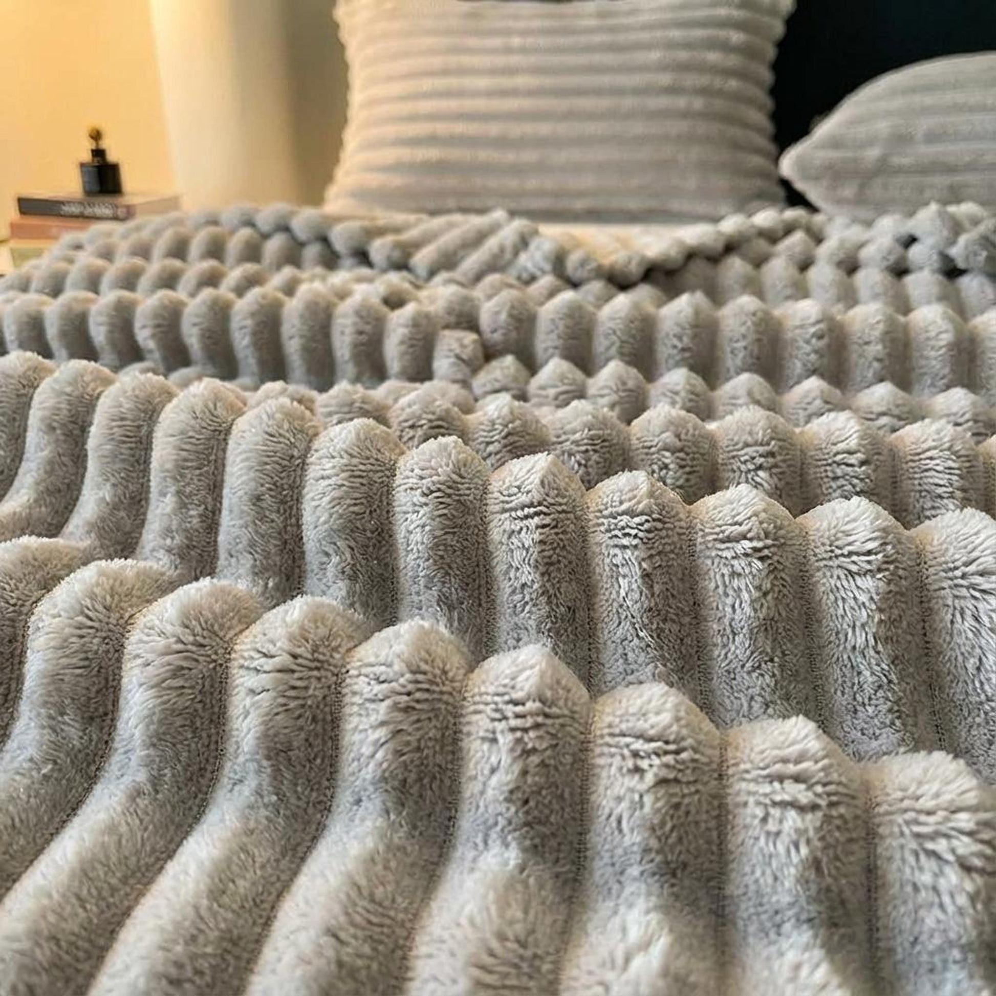 Light gray plush faux fur throw blanket with a ribbed, striped texture.
