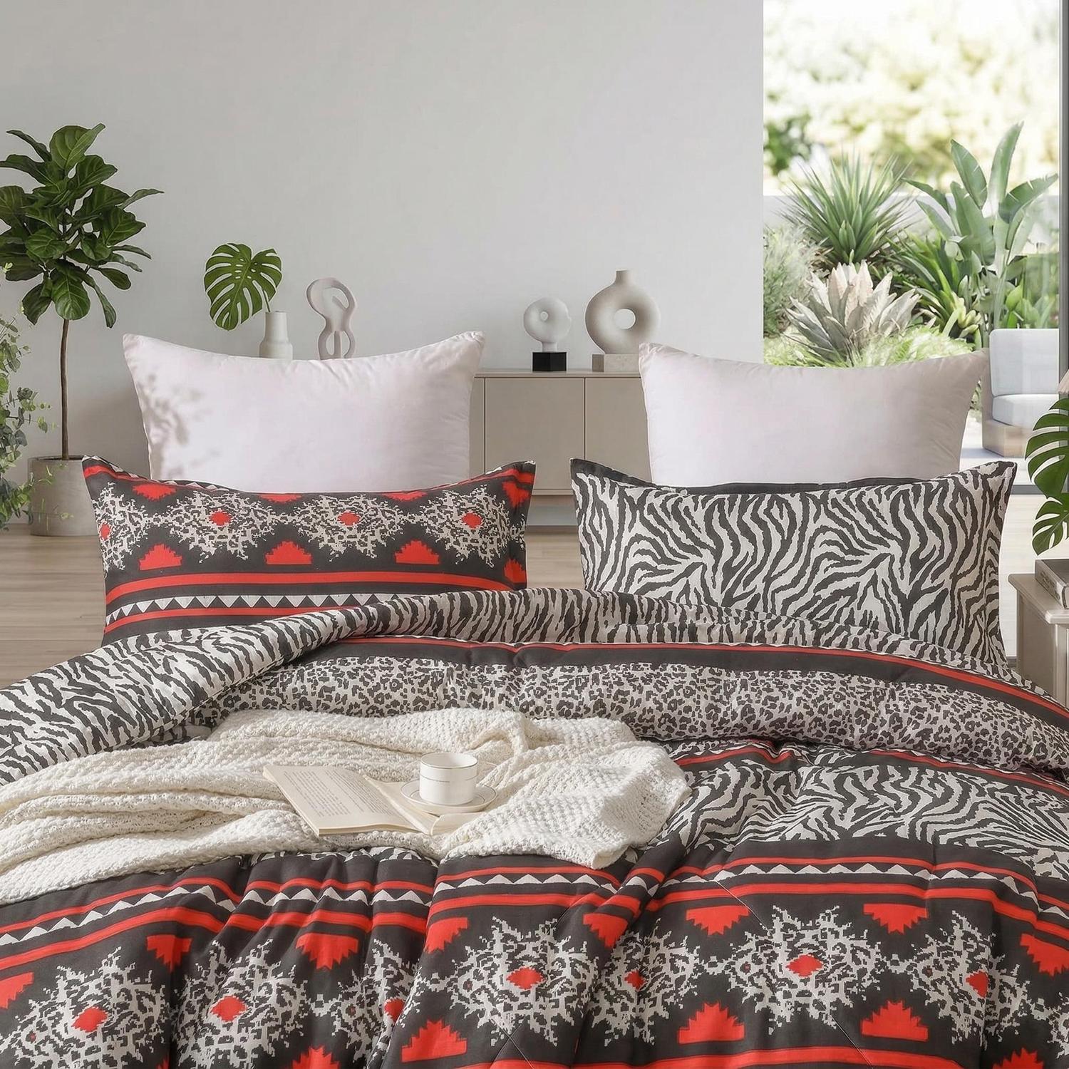 Quilted comforter set with red, gray, and zebra print patterns, two pillow shams, and a white throw.