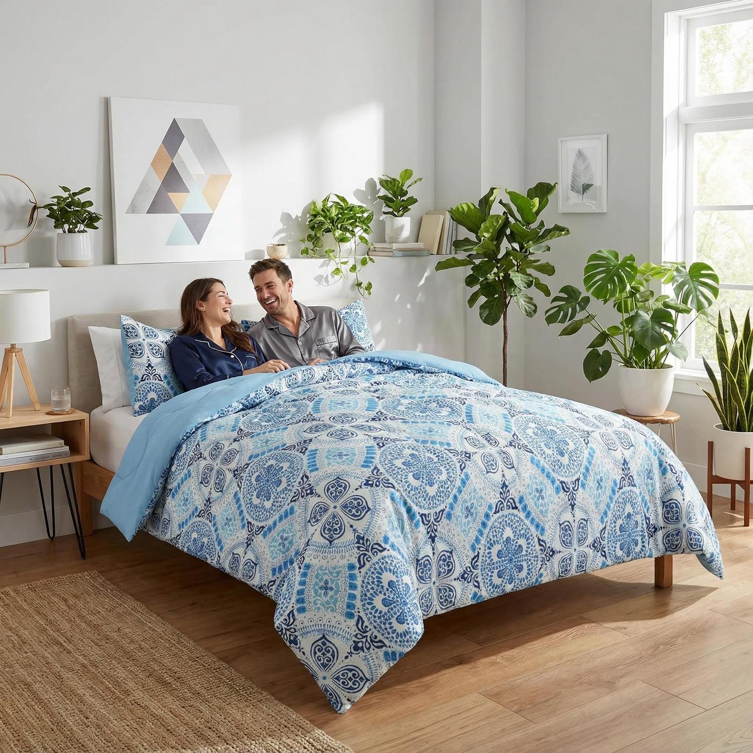 Reversible Aztec Sky Blue comforter set with intricate patterns, down-alternative filling, on a bed with a couple.