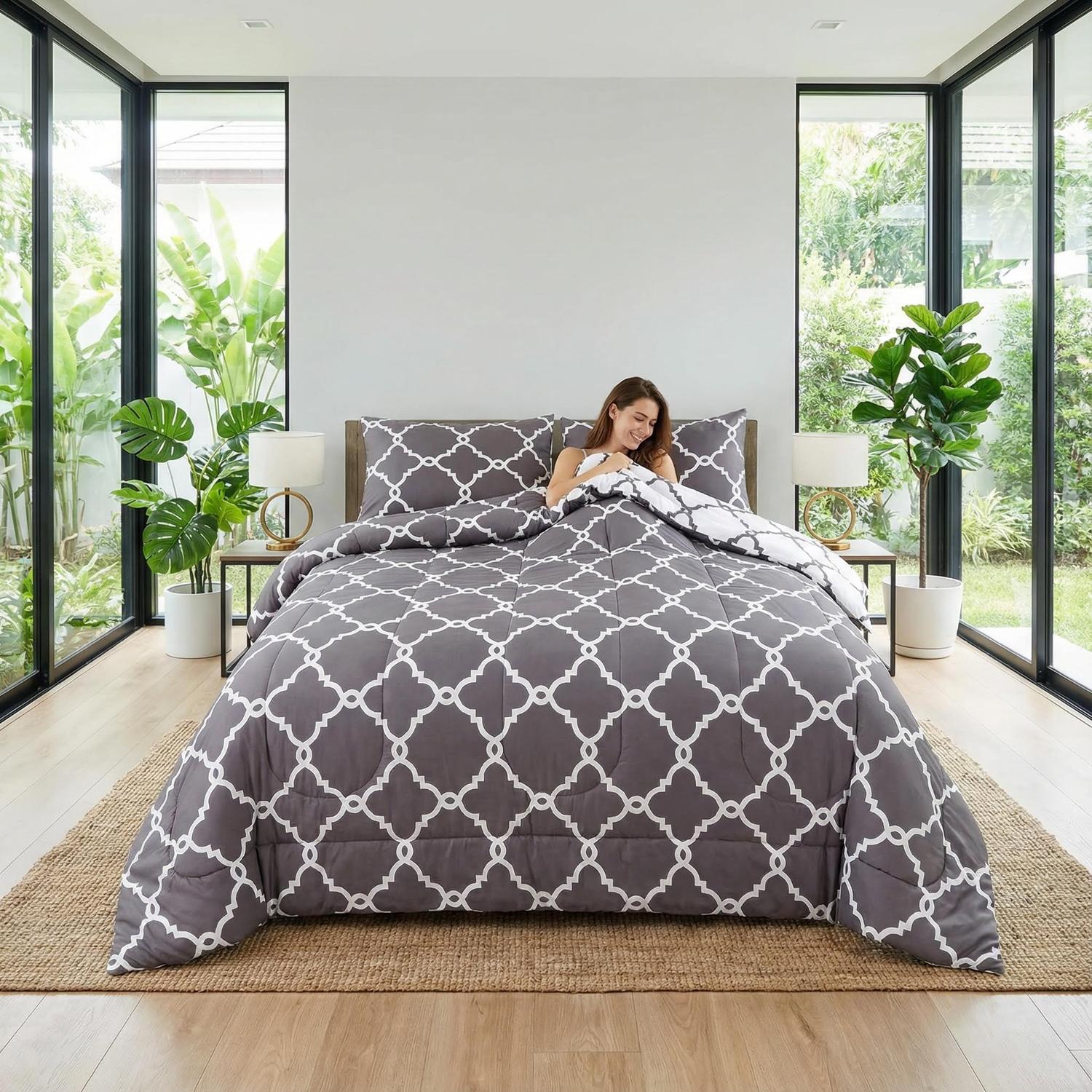 Grey quatrefoil reversible comforter set with down-alternative filling on a bed in a modern bedroom.