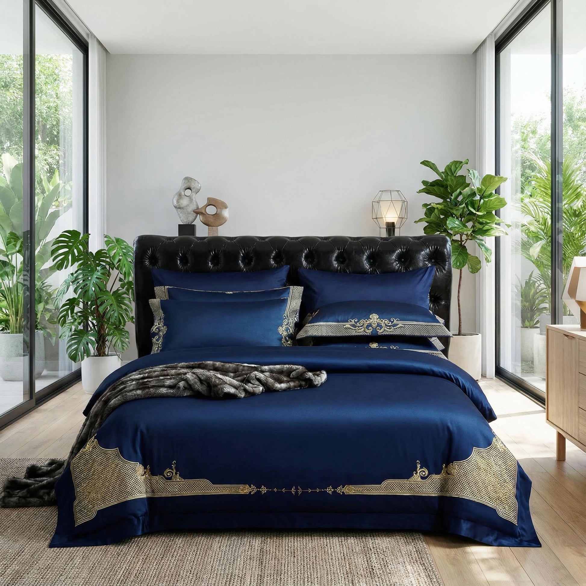 Royal blue cotton bedding set with gold embroidered trim on duvet cover and pillowcases, styled on a bed.