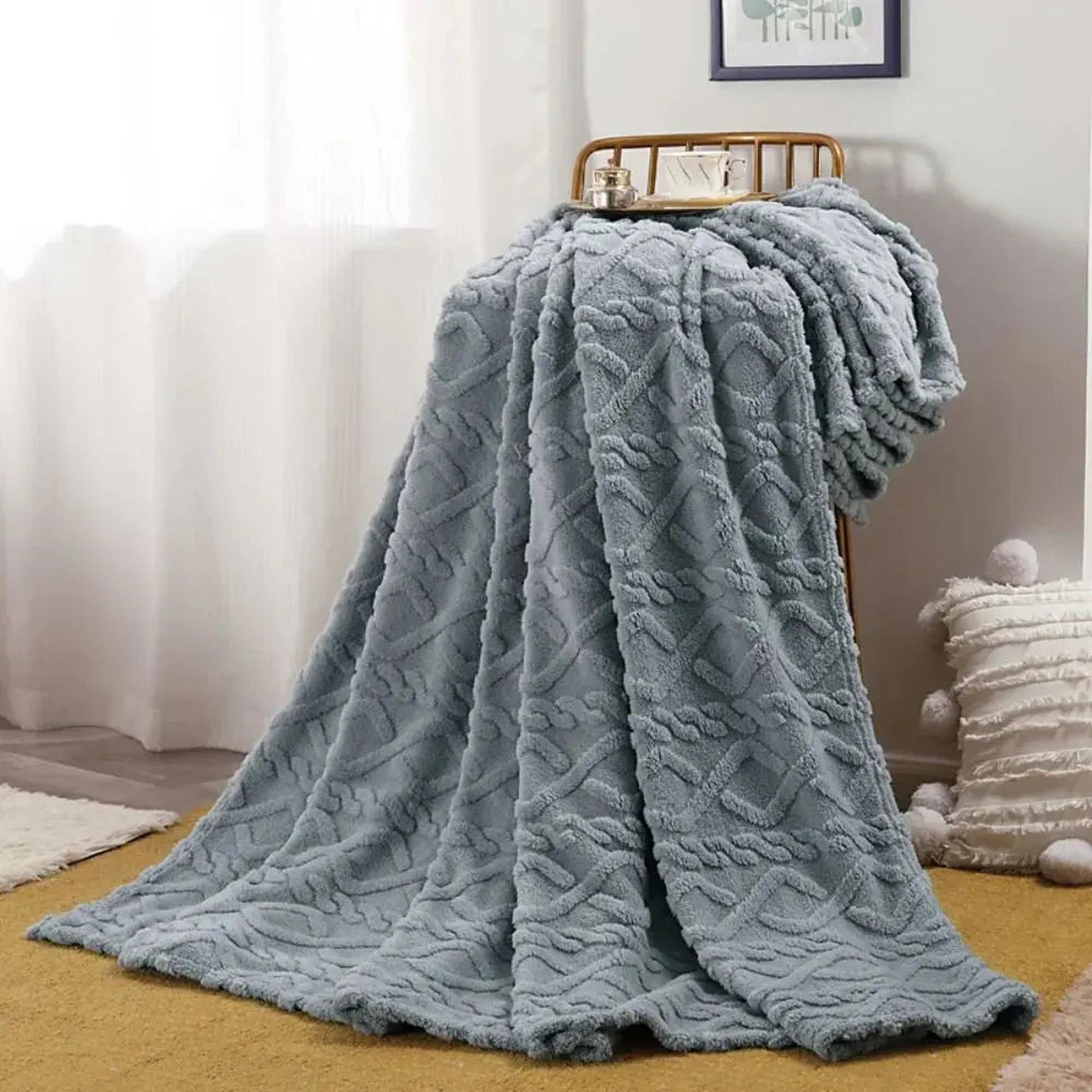 Soft gray ruched faux fur throw blanket draped over a chair, showing its cozy texture and design.