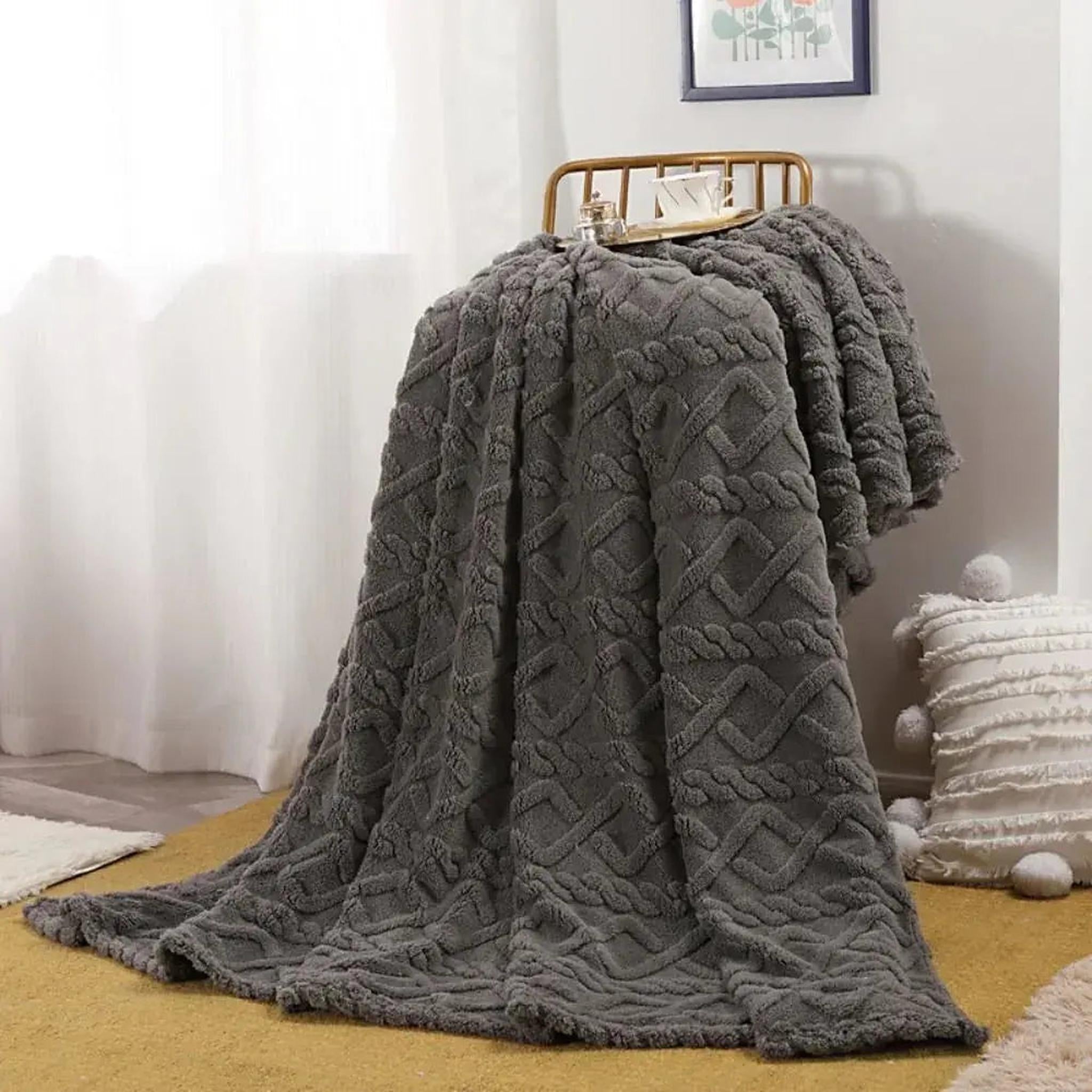 Gray ruched faux fur throw blanket draped over a gold chair, showcasing its soft texture and geometric pattern.
