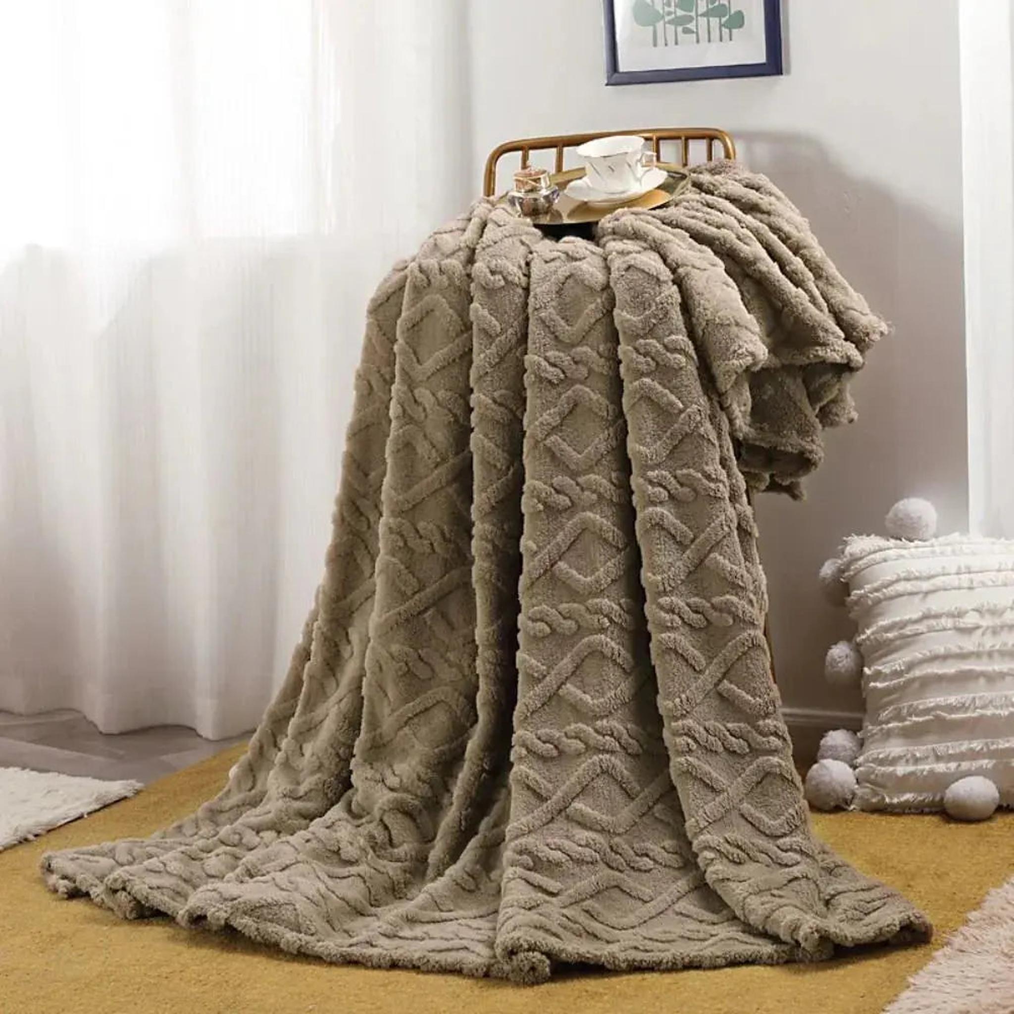 Soft, ruched faux fur throw blanket in a warm taupe color draped over a chair.