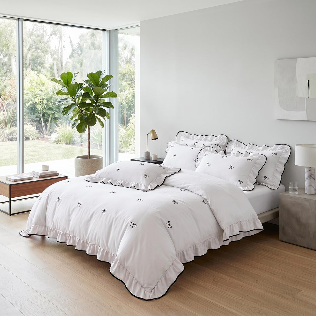 White microfiber ruffle bow duvet cover set with black embroidered bows and ruffled edges on a bed.