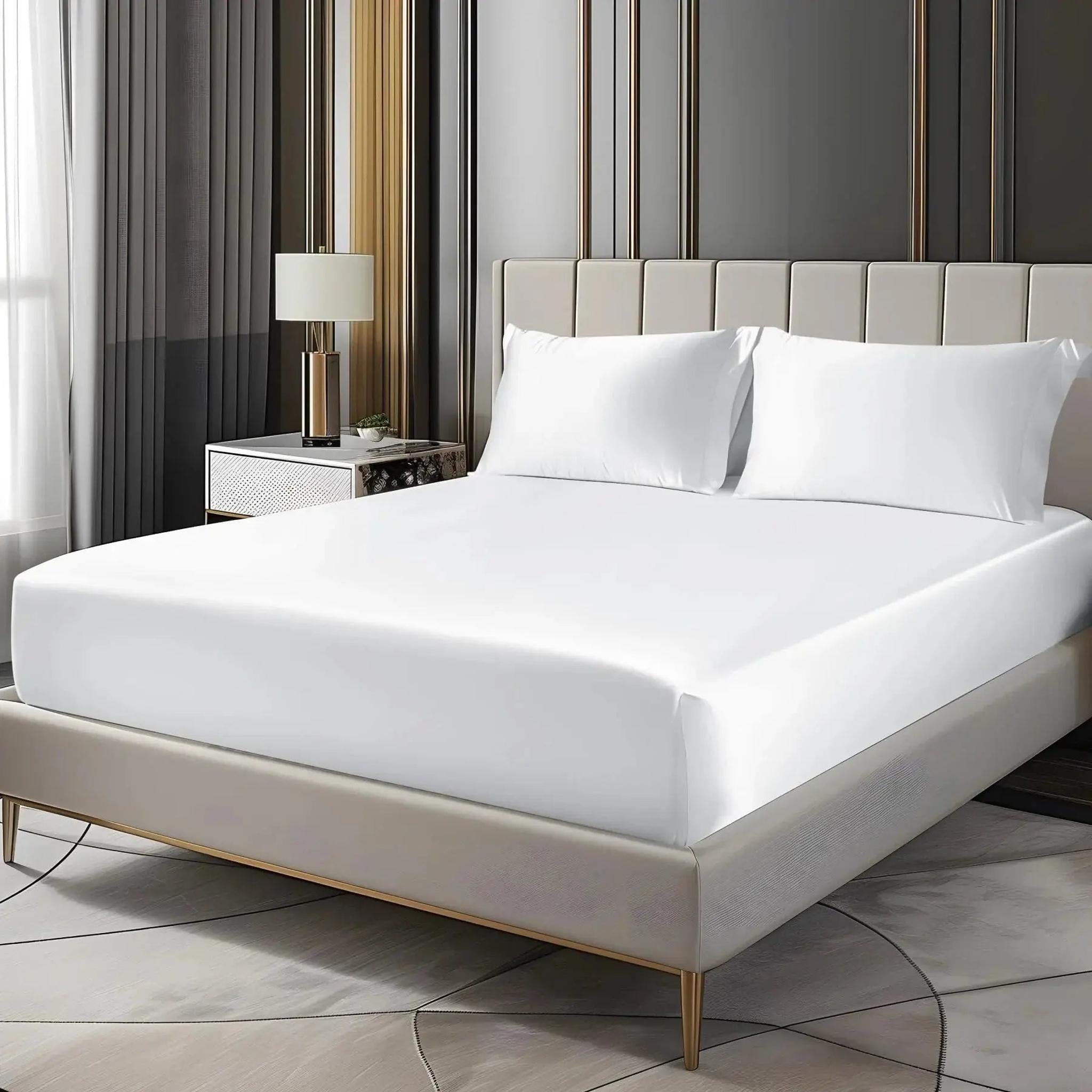 White satin fitted sheet set with deep pockets and two pillowcases on an elegant bed.