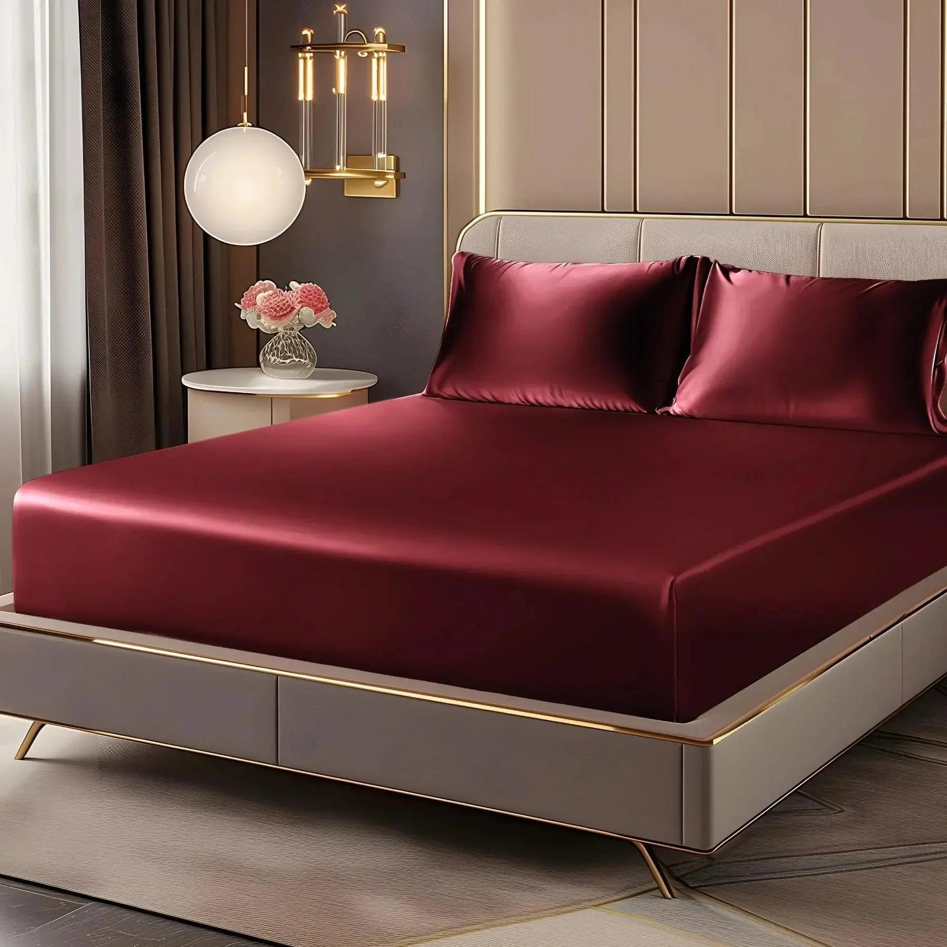 Deep pocket satin fitted sheet set in elegant burgundy, with matching pillowcases on a modern bed.