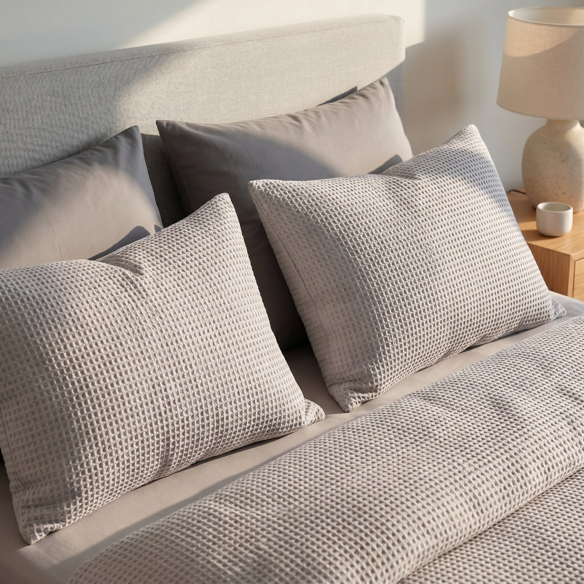 Soft grey waffle-knit cotton duvet cover set with matching textured pillowcases on a modern bed.