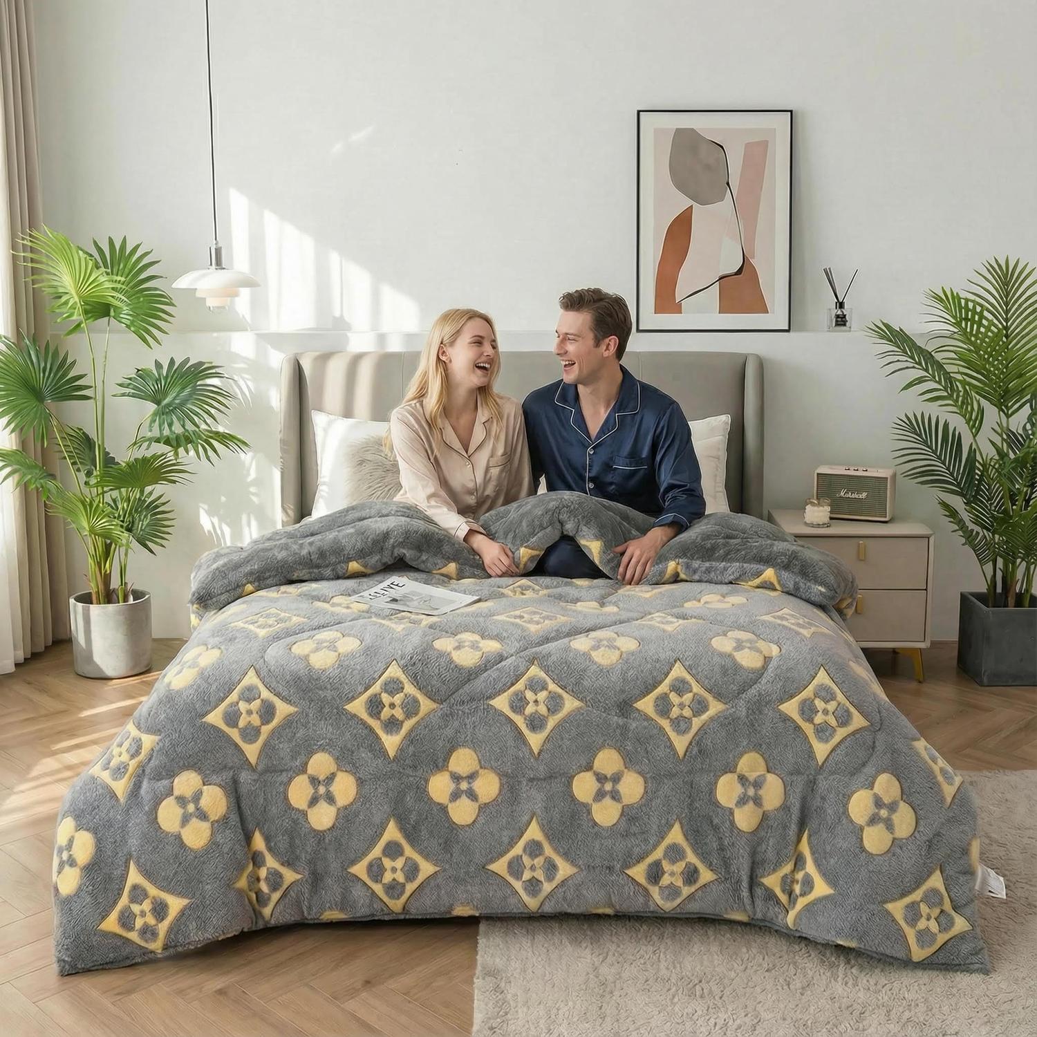 Couple on a bed with a gray and yellow snowflake velvet quilt, featuring a modern geometric pattern.
